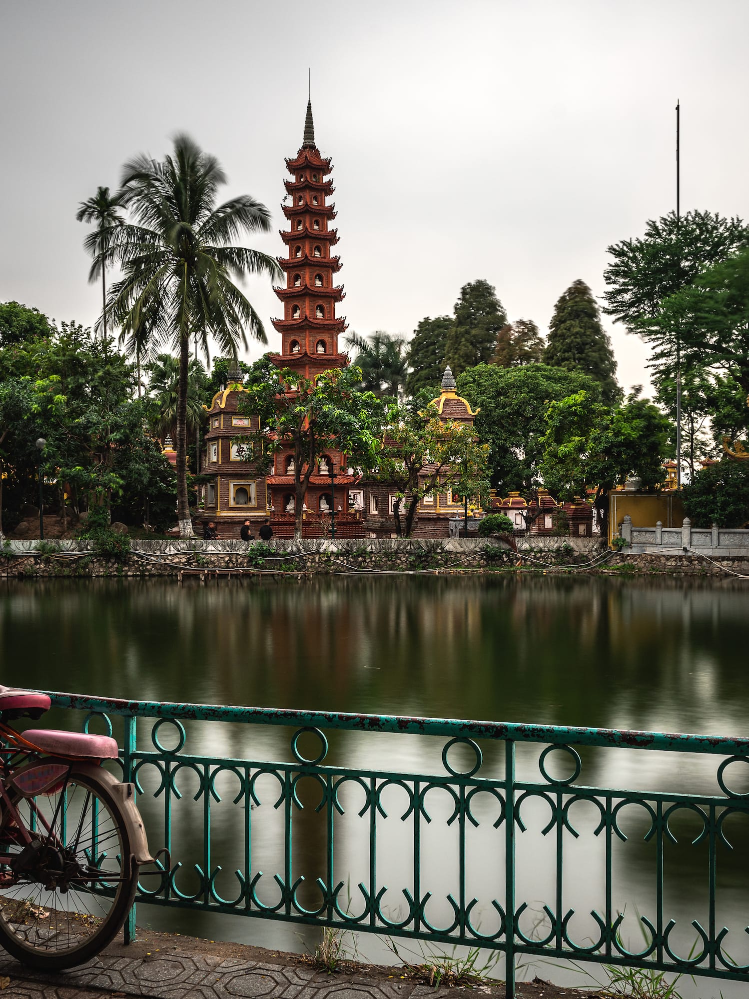 a bicycle parked on a bridge by a body of water