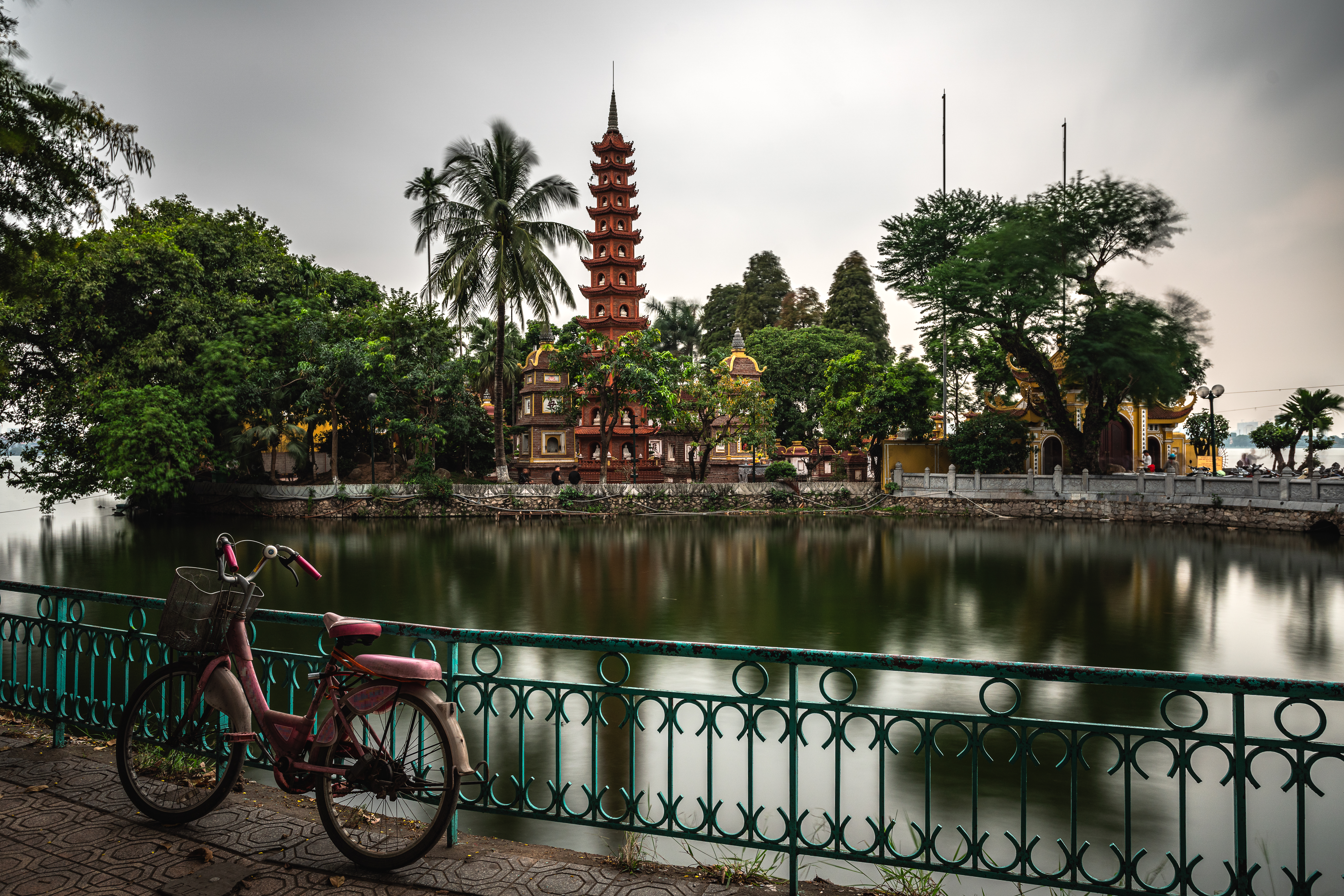 a bicycle parked on a bridge by a body of water