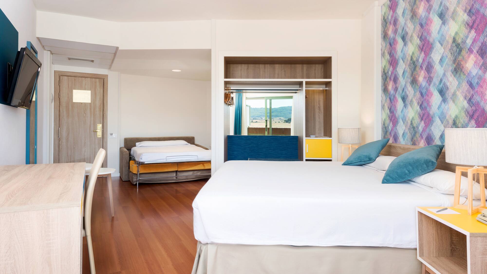 a room with a bed and two beds