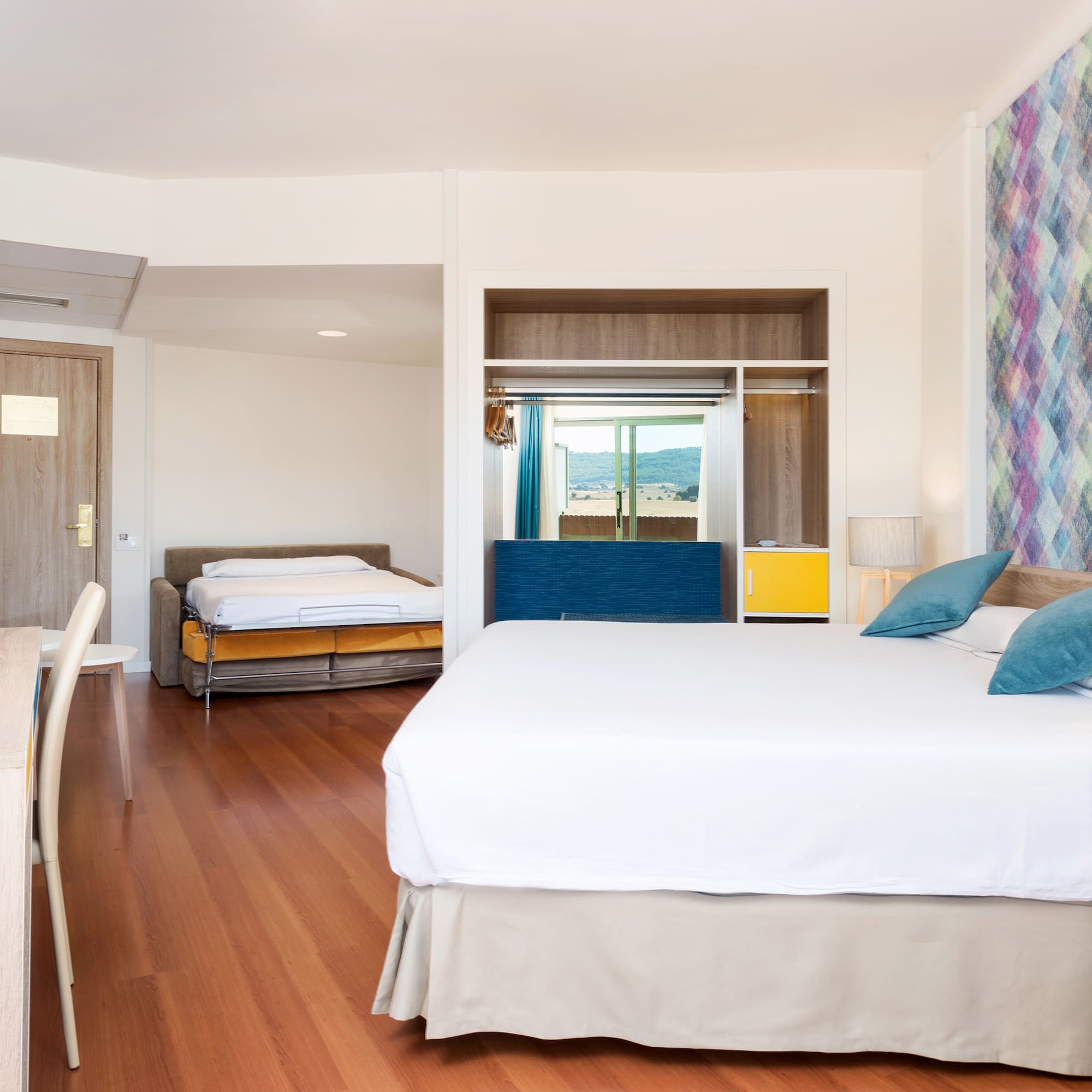 a room with a bed and two beds