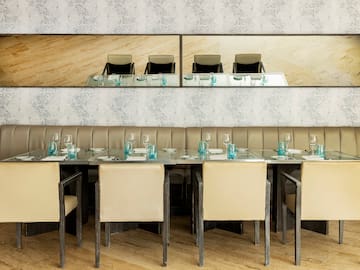 a long table with chairs and glasses on it