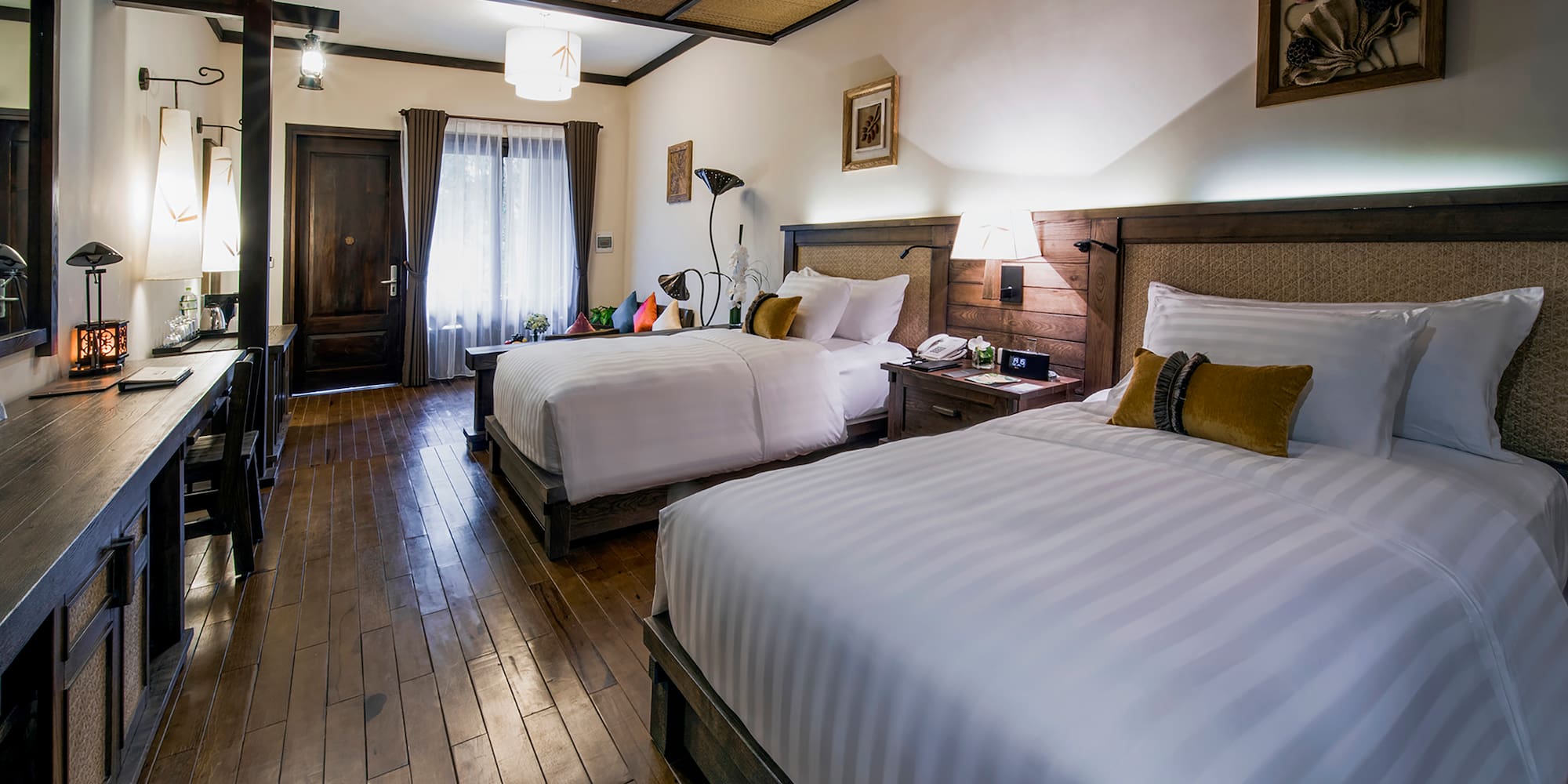 a room with two beds and a wood floor