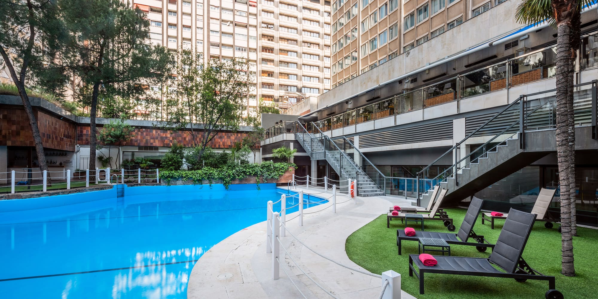 a swimming pool with chairs and a building in the background