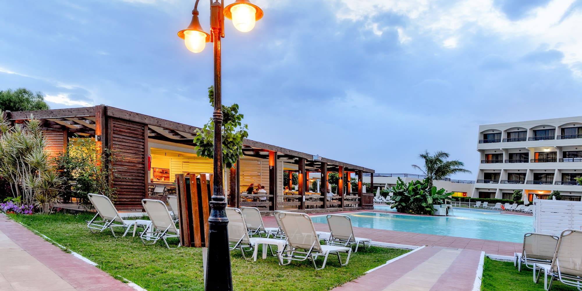 a pool with a light post and lawn chairs