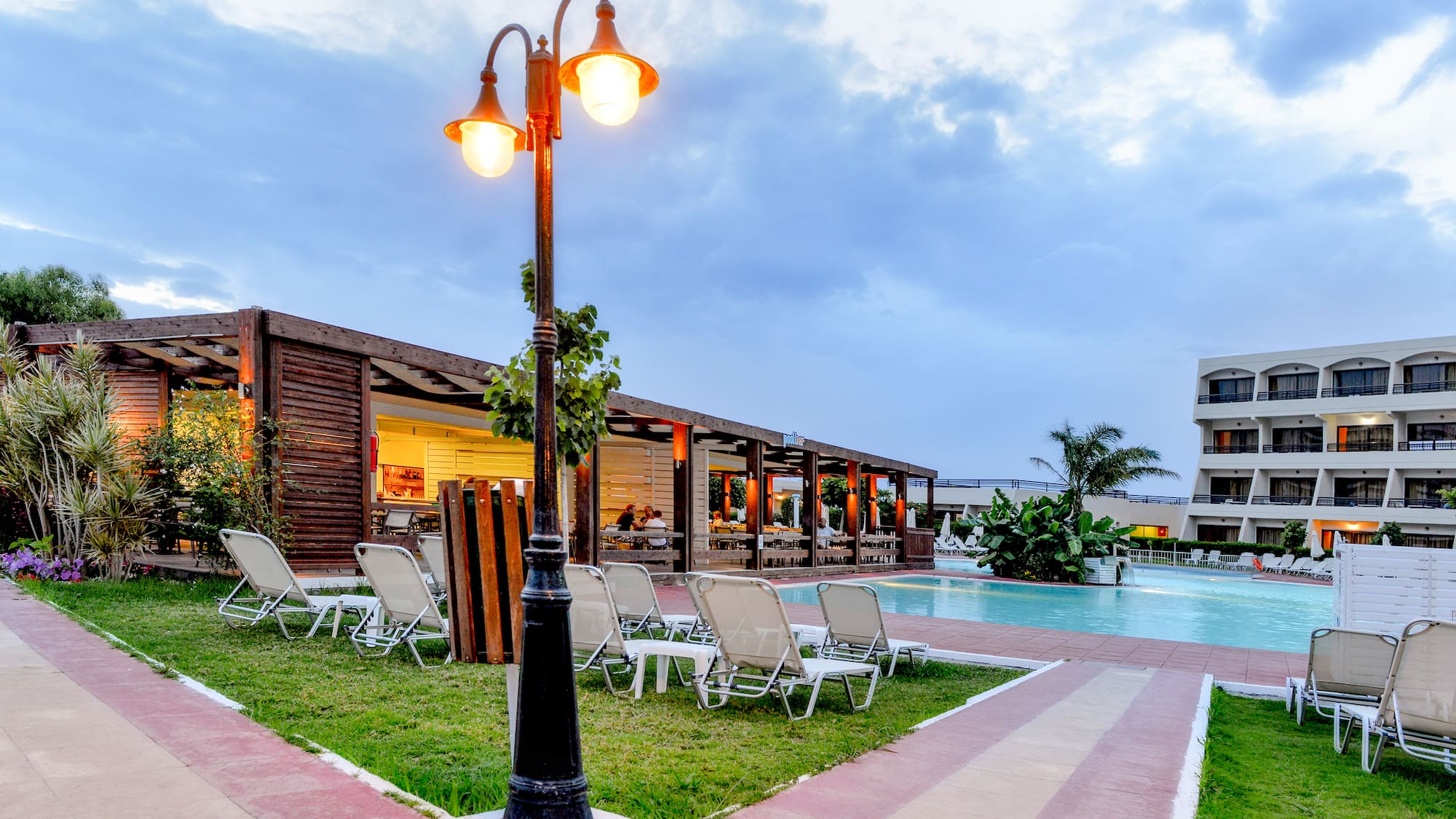 a pool with a light post and lawn chairs