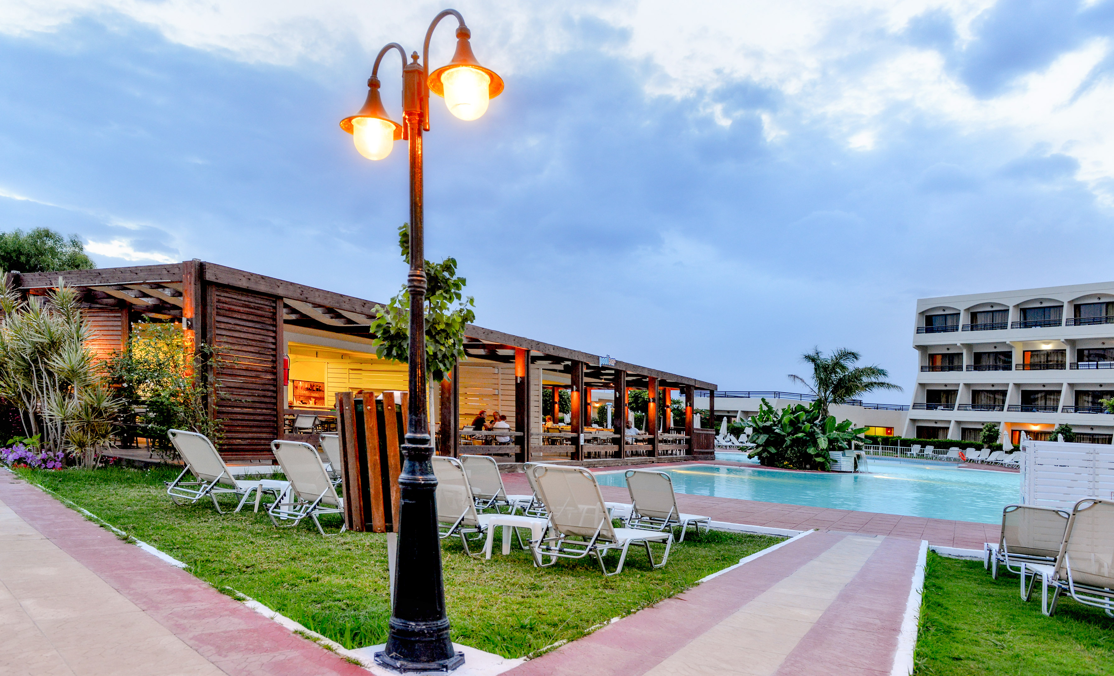 a pool with a light post and lawn chairs