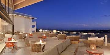 a patio with tables and chairs on a deck