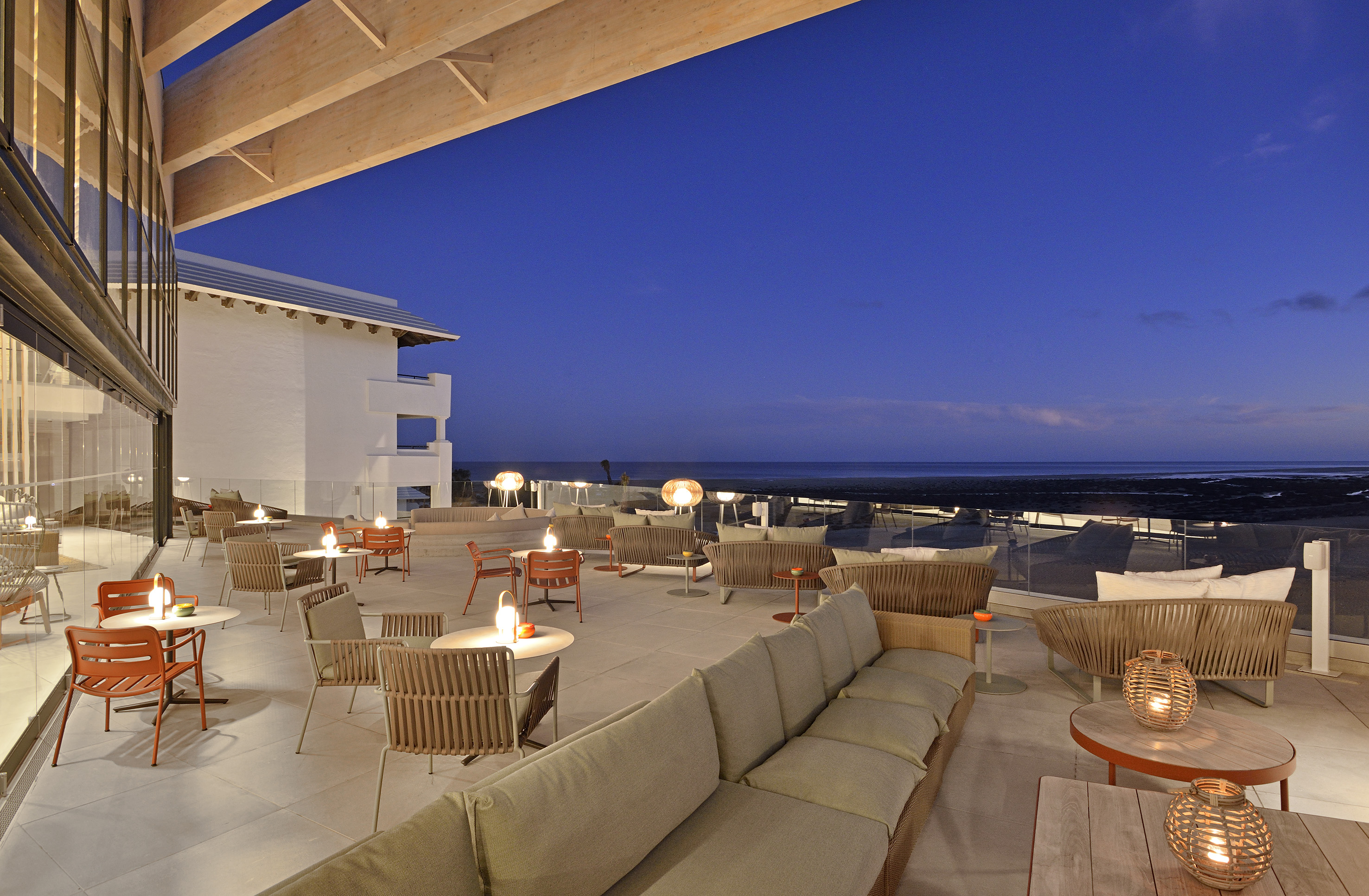 a patio with tables and chairs on a deck