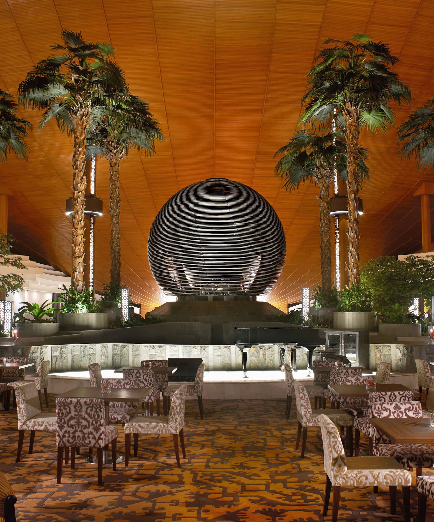 a room with tables and chairs and palm trees