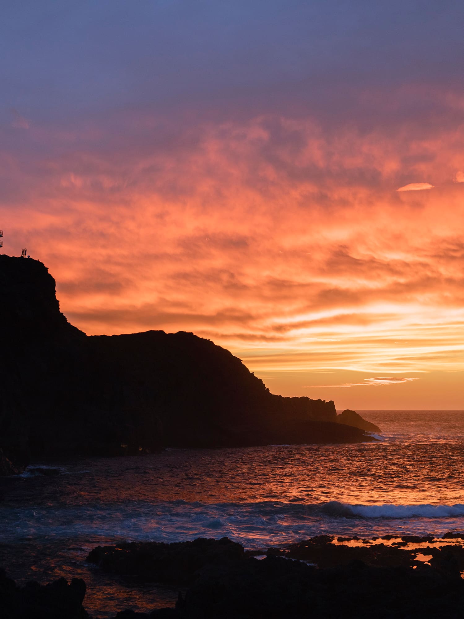 a sunset over a rocky beach