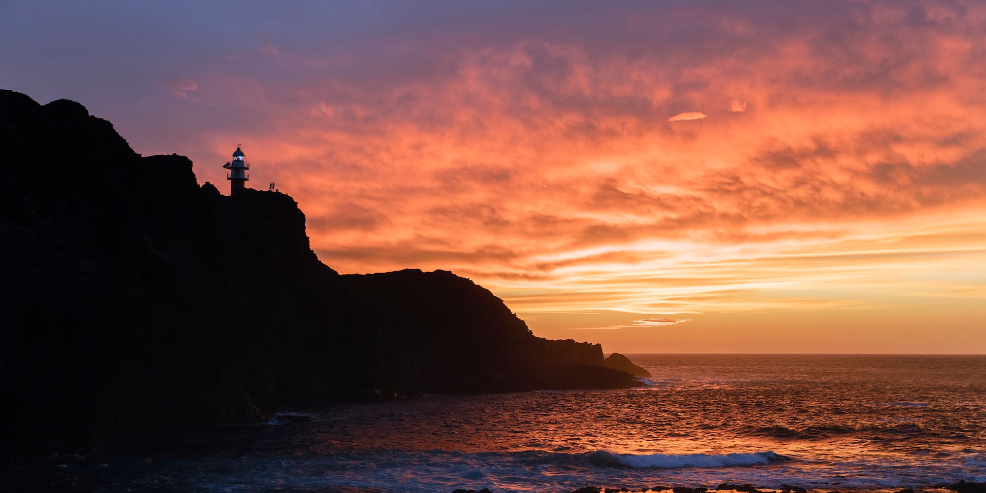 a sunset over a rocky beach