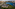Aerial city view: Modern lakeside buildings, green parks, highway, and urban skyline.