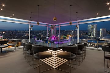 a bar with chairs and a view of a city