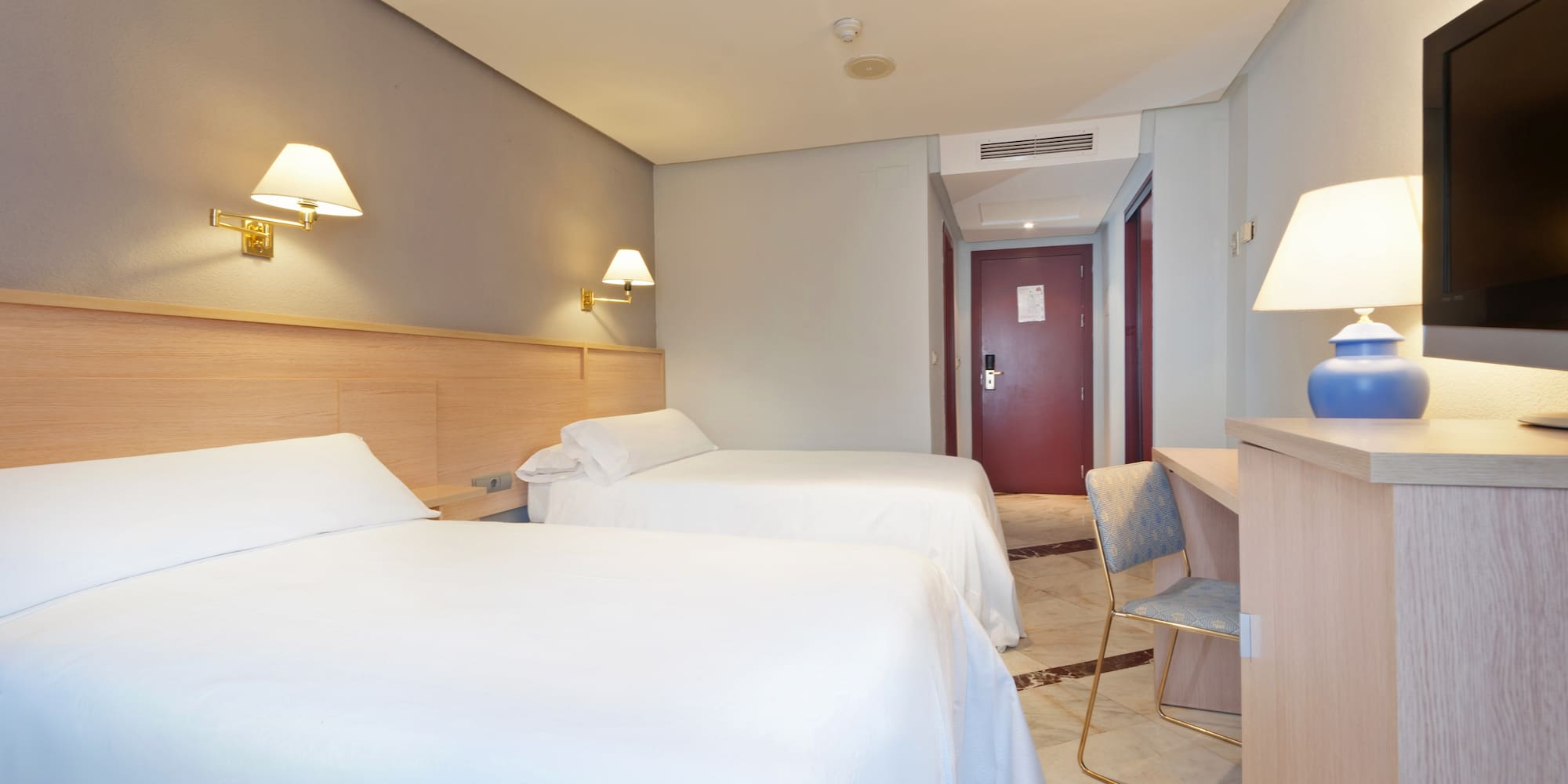 a room with two beds and a desk