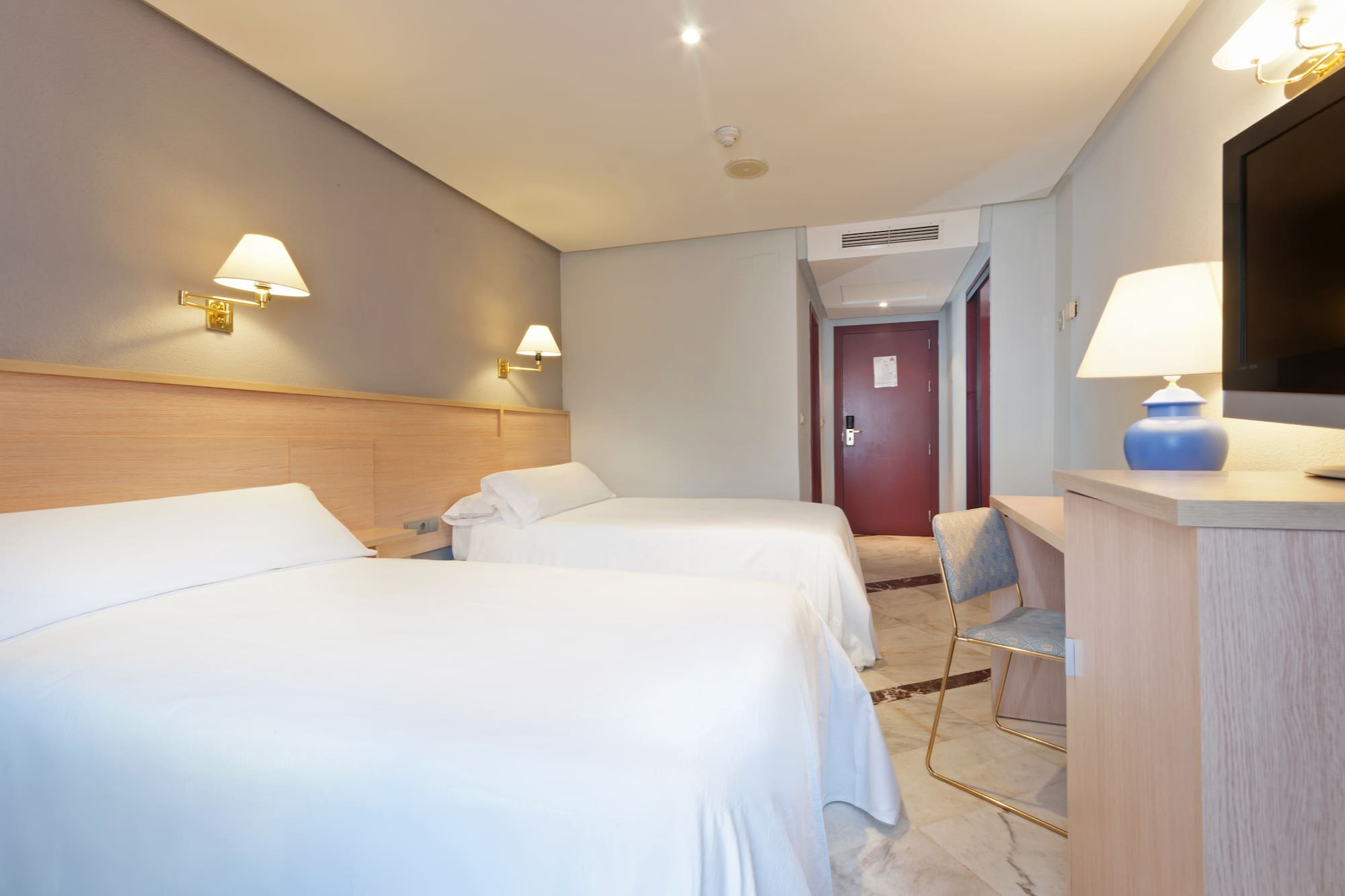 a room with two beds and a desk