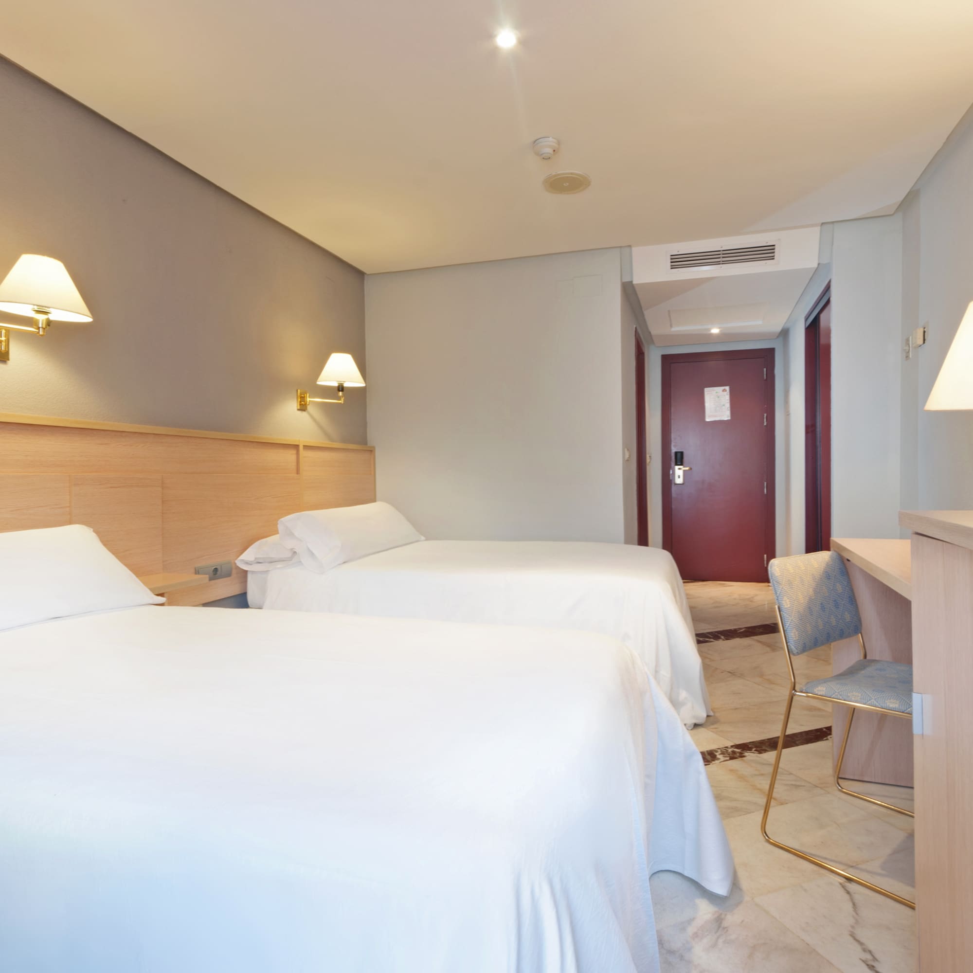 a room with two beds and a desk