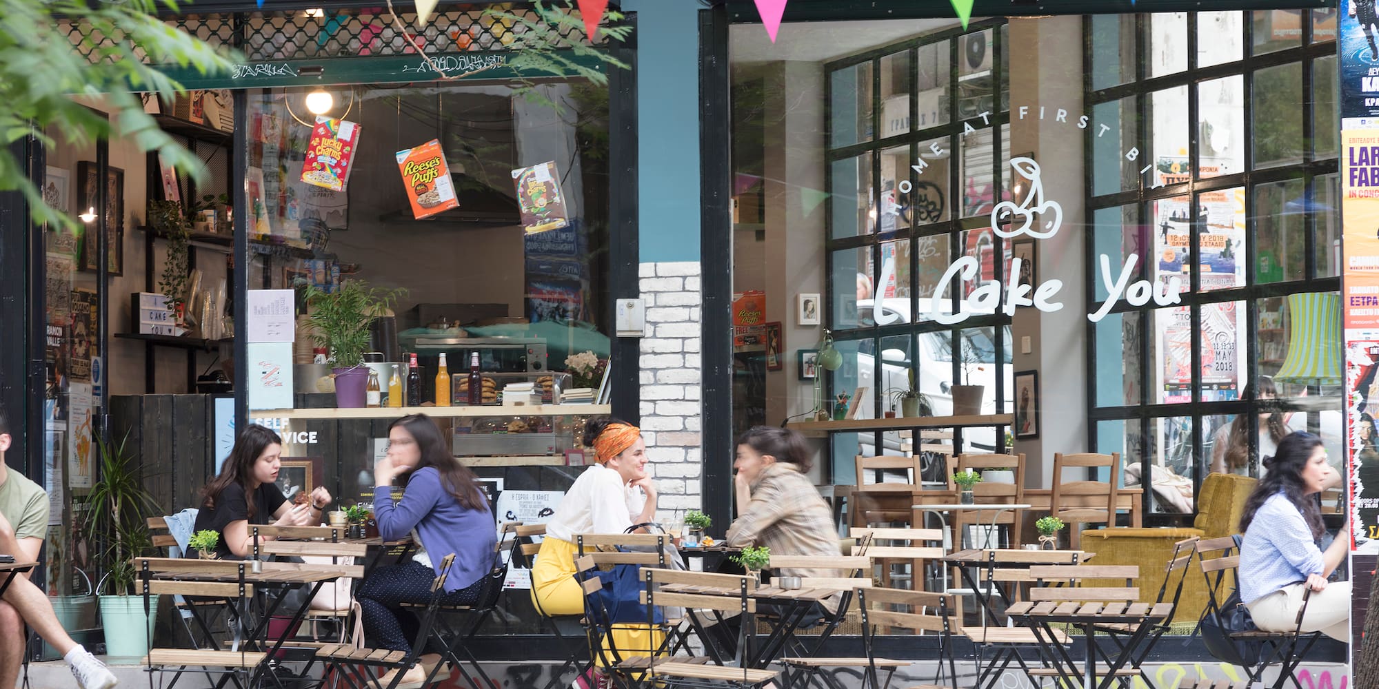 a group of people sitting at tables outside a restaurant