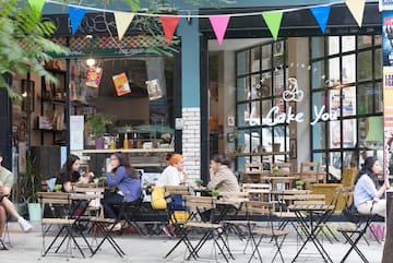 a group of people sitting at tables outside a restaurant