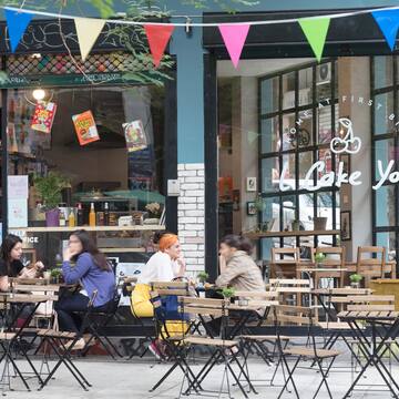 a group of people sitting at tables outside a restaurant
