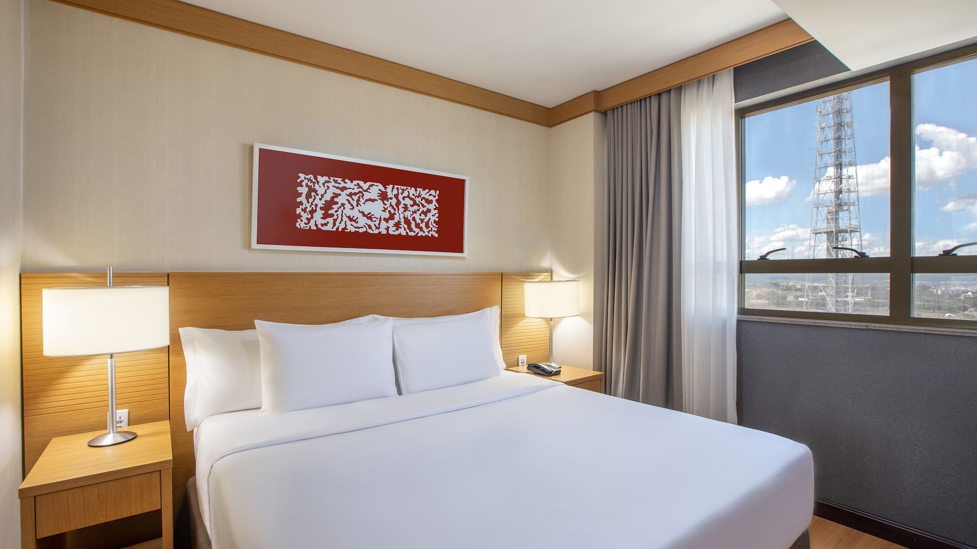 a bed with white sheets and a lamp on the side