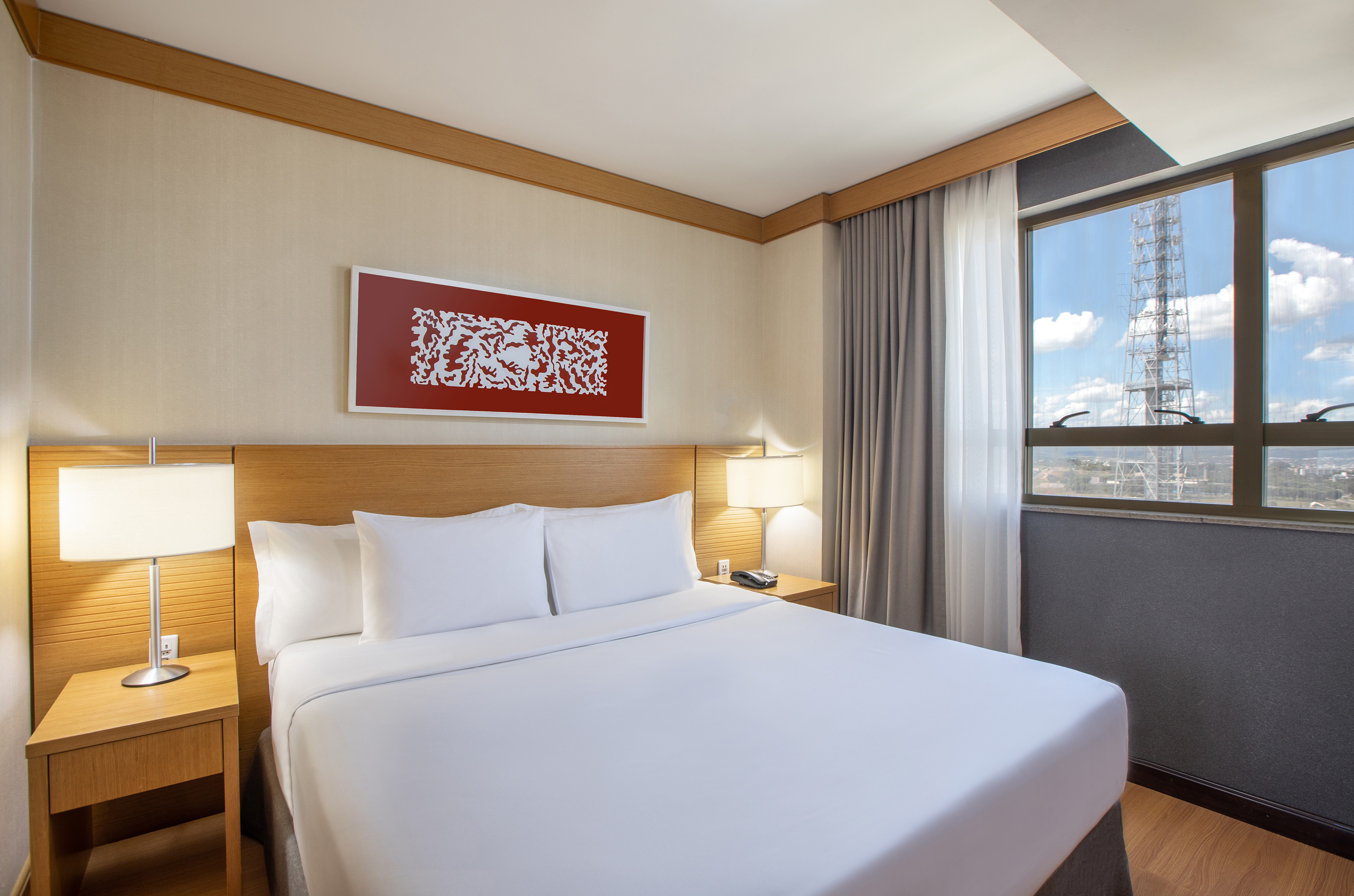 a bed with white sheets and a lamp on the side