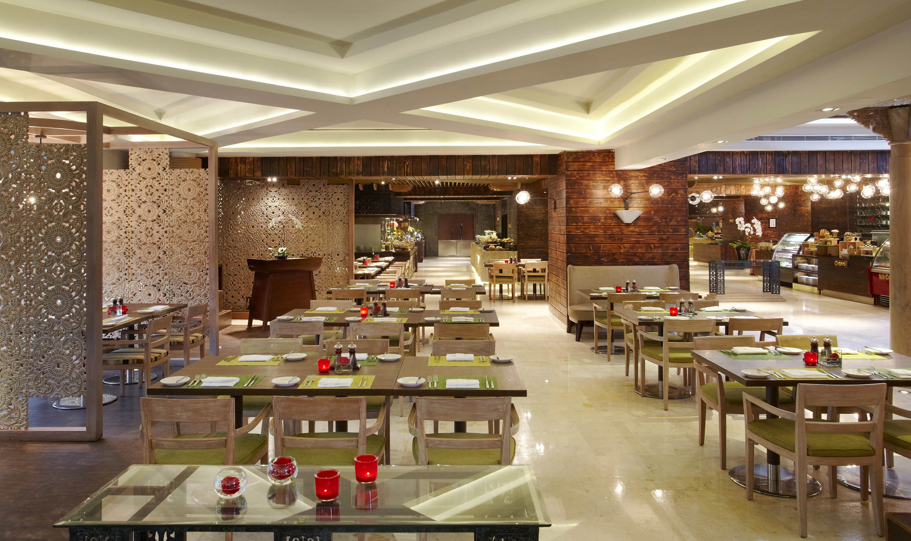 Modern restaurant dining room with set tables, decorative screens, and buffet.