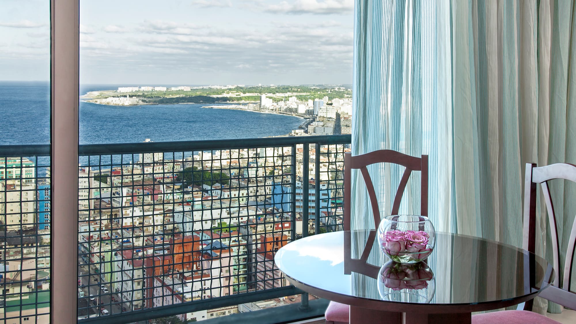 a table with a vase of flowers on it overlooking a city