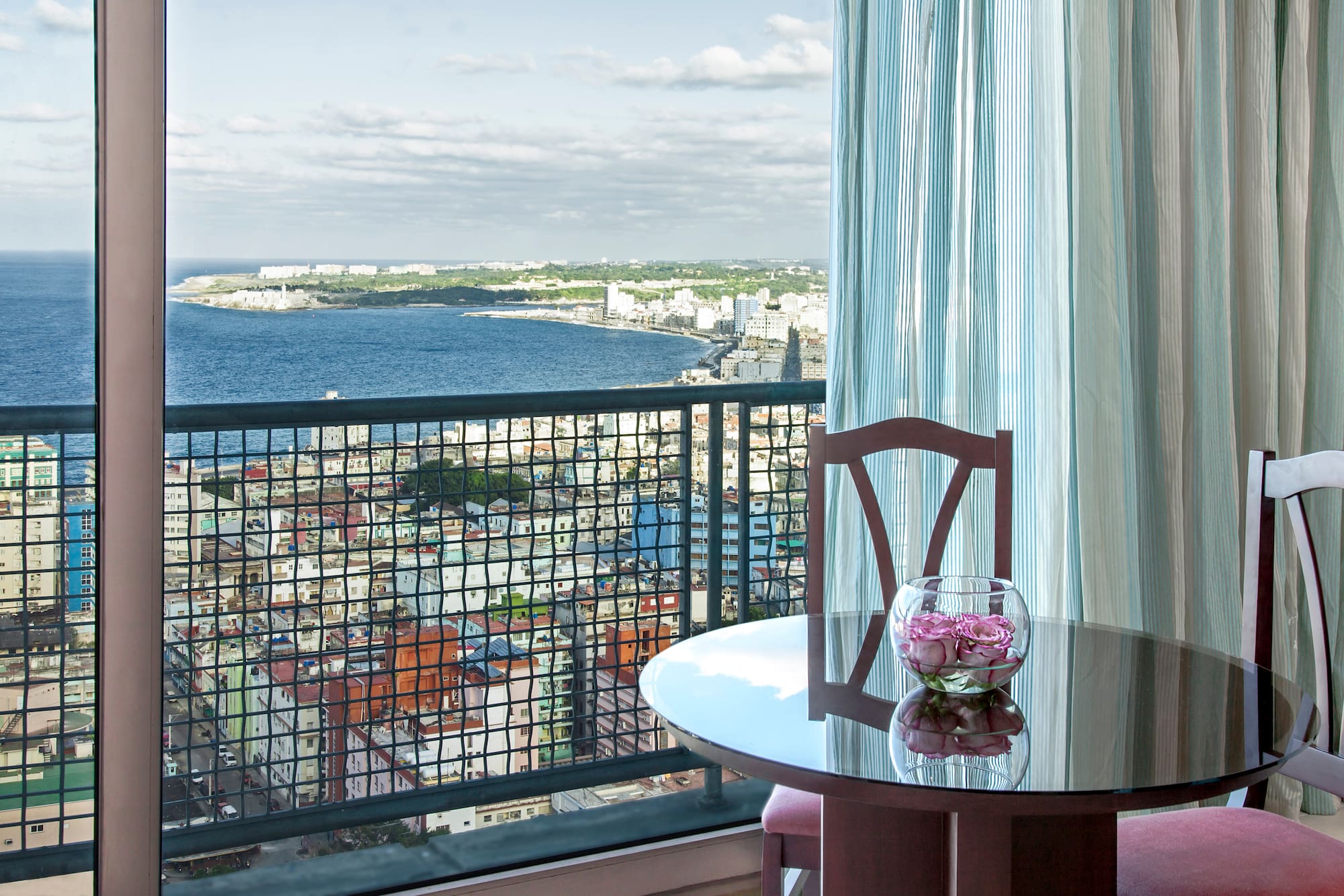 a table with a vase of flowers on it overlooking a city