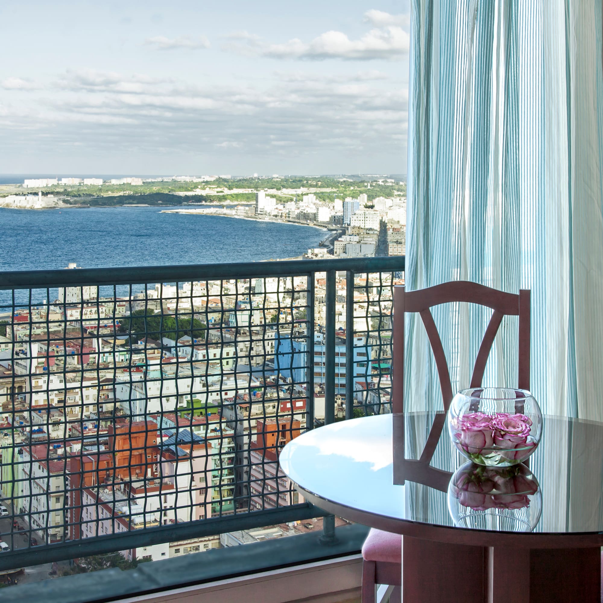 a table with a vase of flowers on it overlooking a city