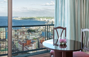 a table with a vase of flowers on it overlooking a city