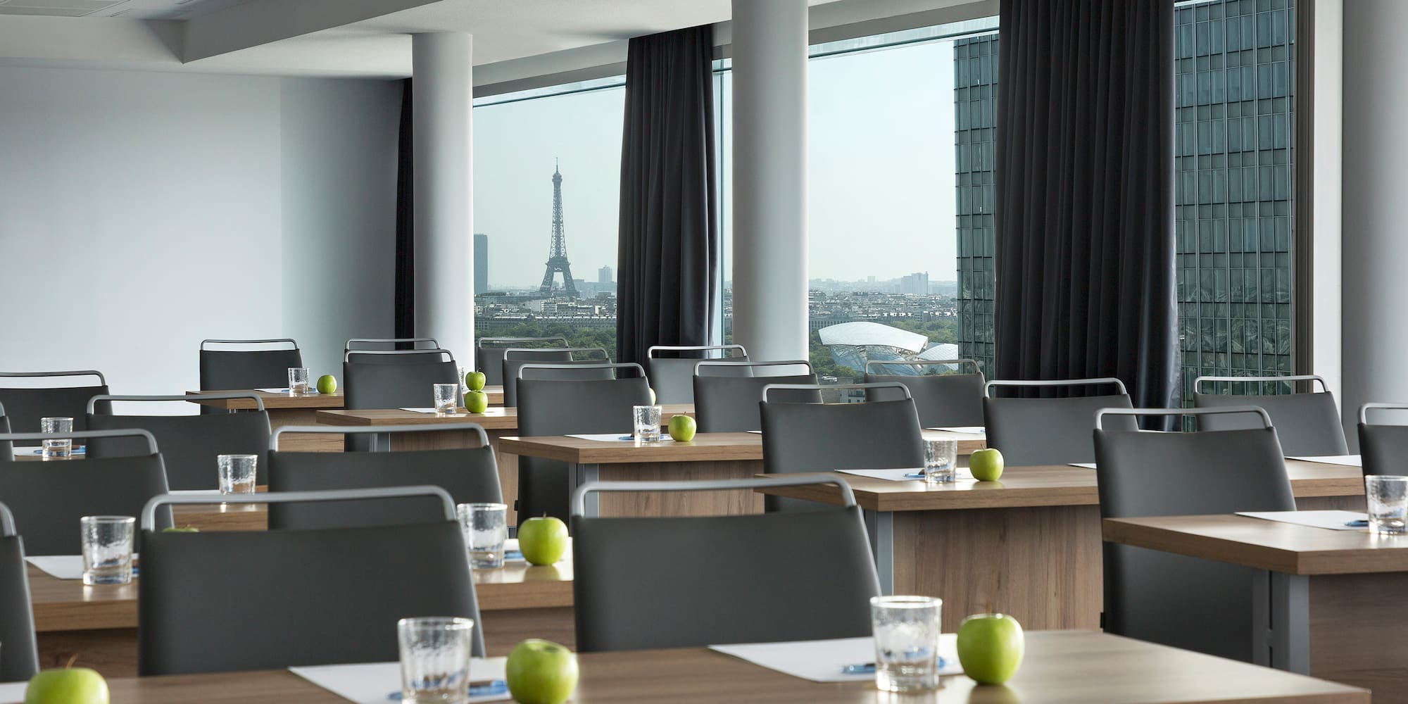 a room with tables and chairs and a view of the eiffel tower