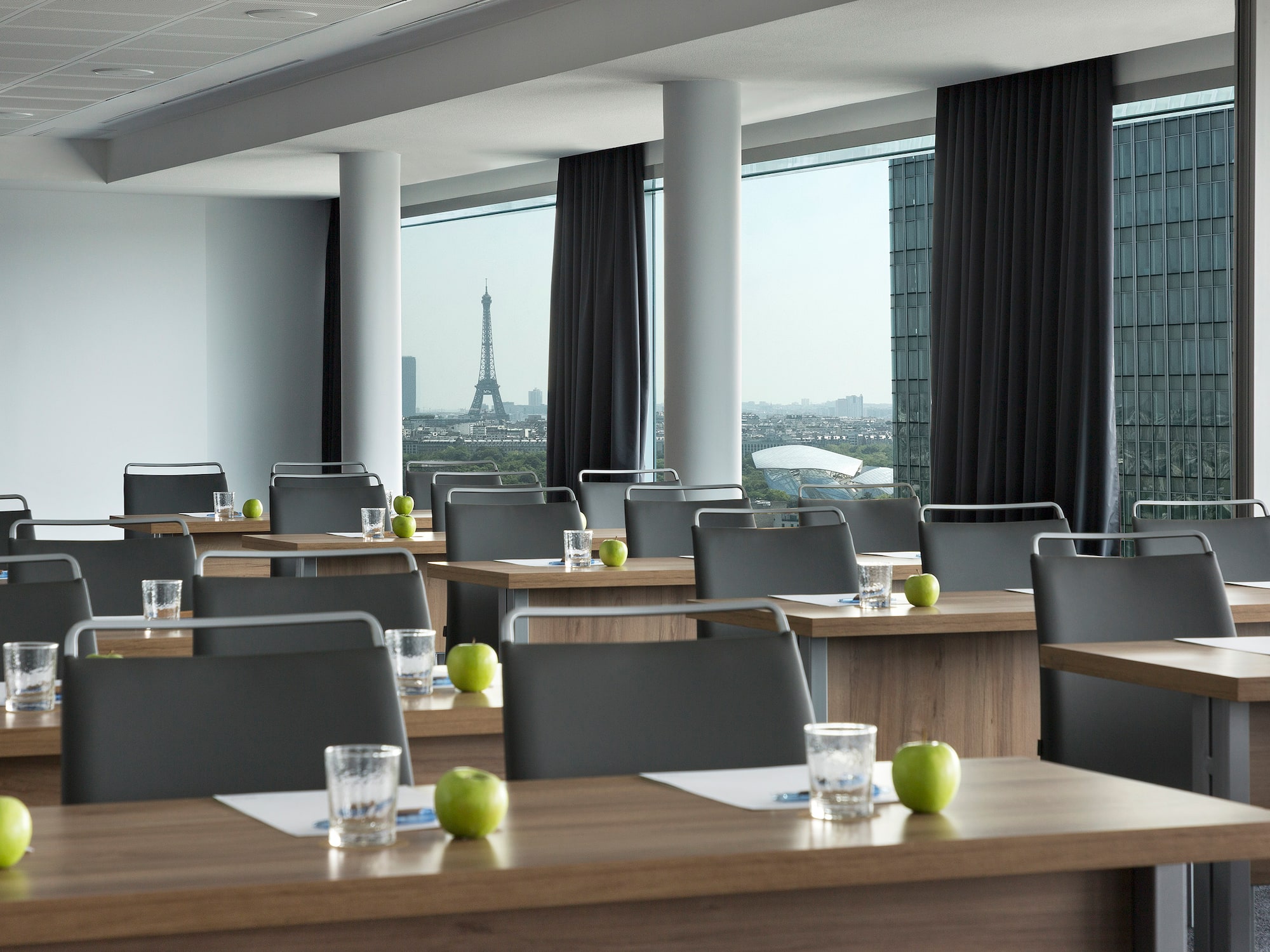 a room with tables and chairs and a view of the eiffel tower