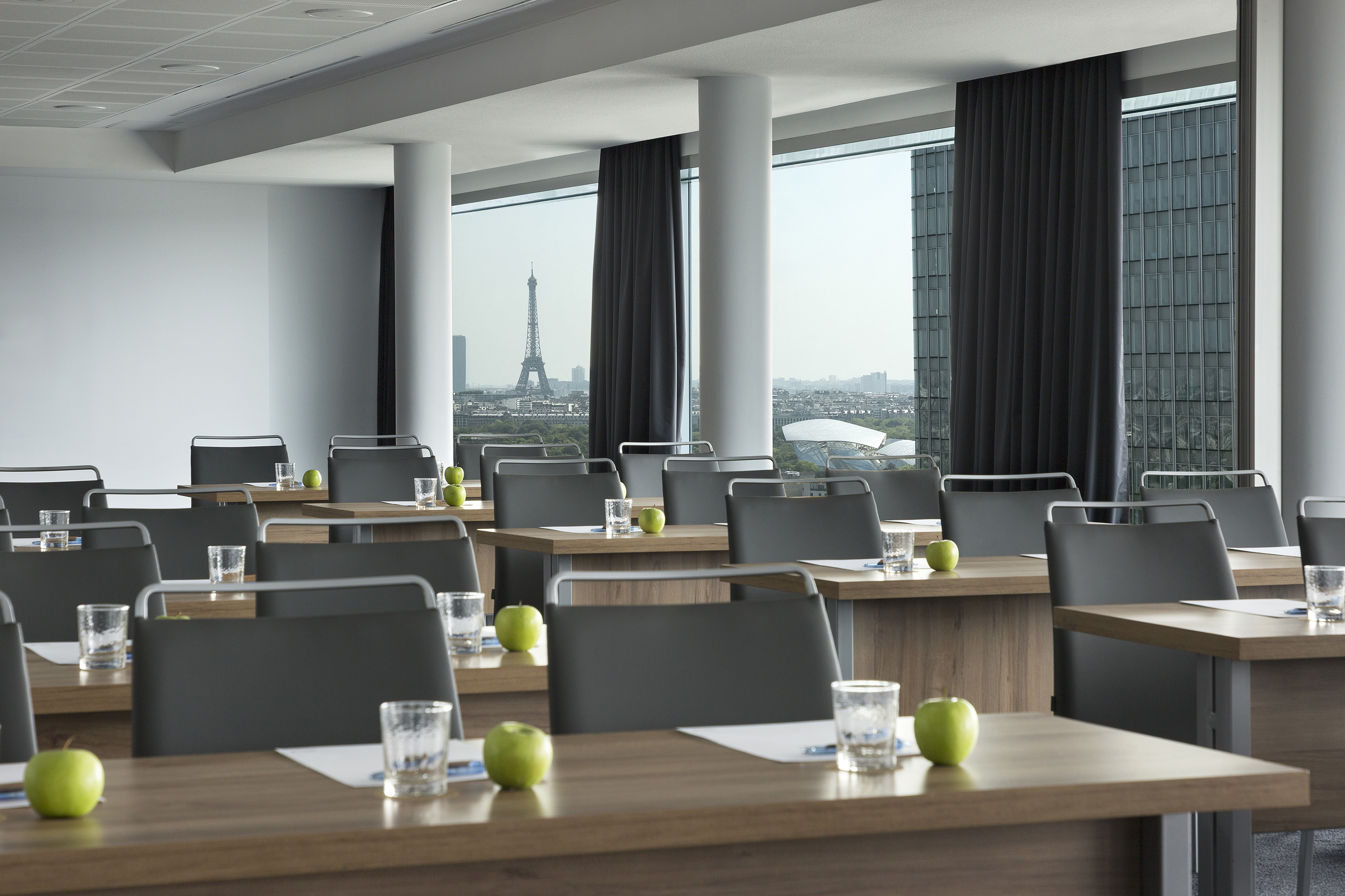 a room with tables and chairs and a view of the eiffel tower