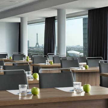 a room with tables and chairs and a view of the eiffel tower
