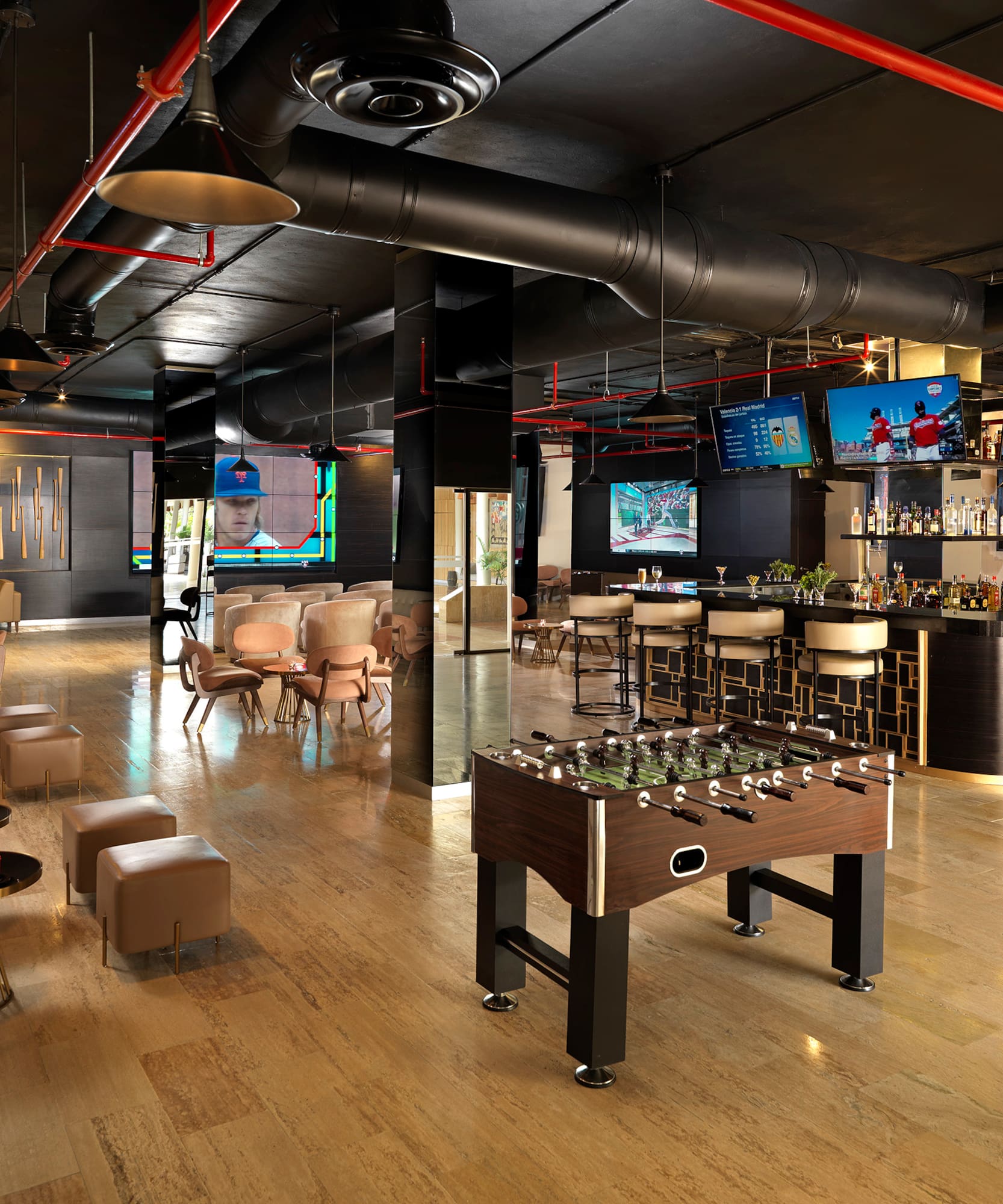 a room with a foosball table and tables and chairs