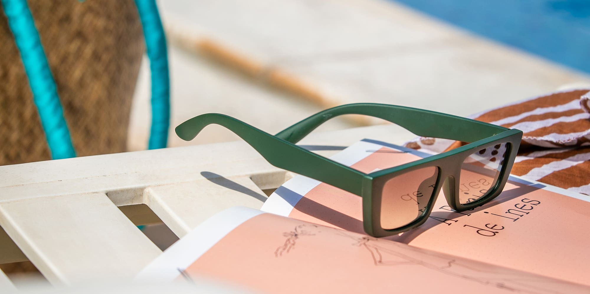 sunglasses on a chair by a pool