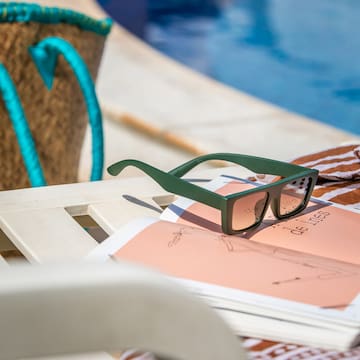 sunglasses on a chair by a pool