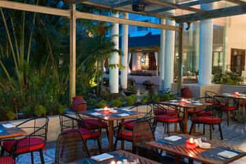 tables outside a restaurant with red and white striped chairs and tables
