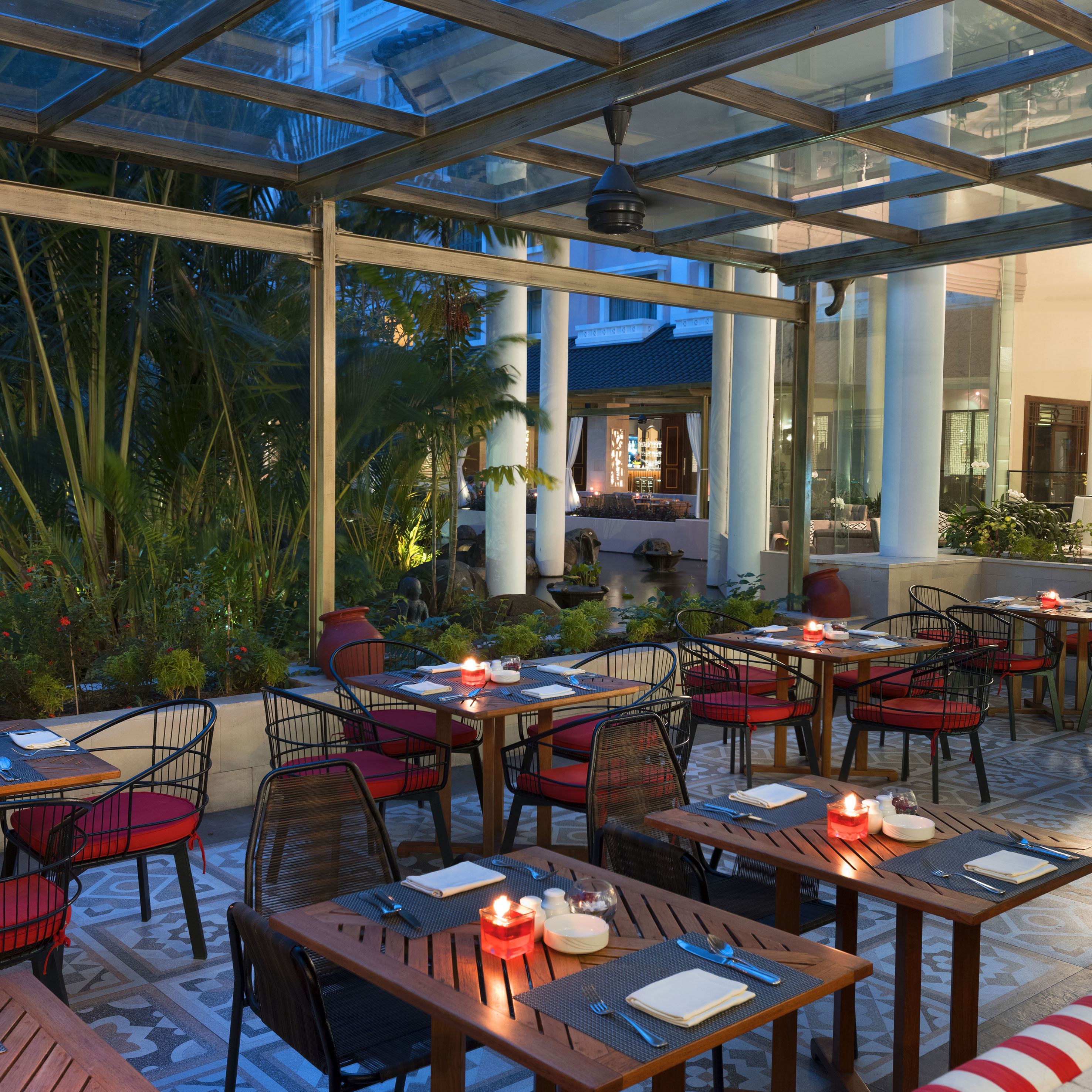 tables outside a restaurant with red and white striped chairs and tables