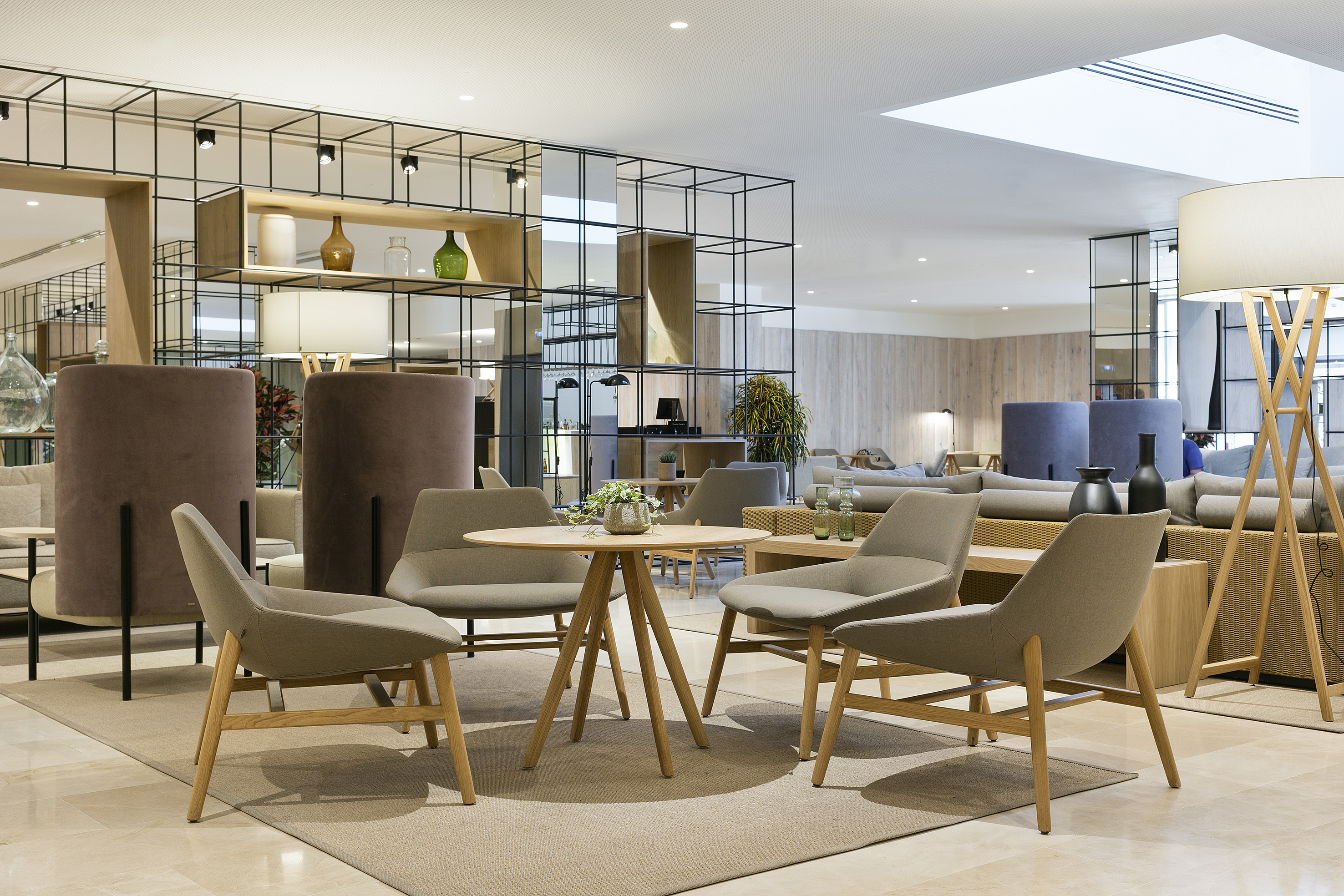 Chic modern lounge with comfortable seating, round table, and decorative divider.