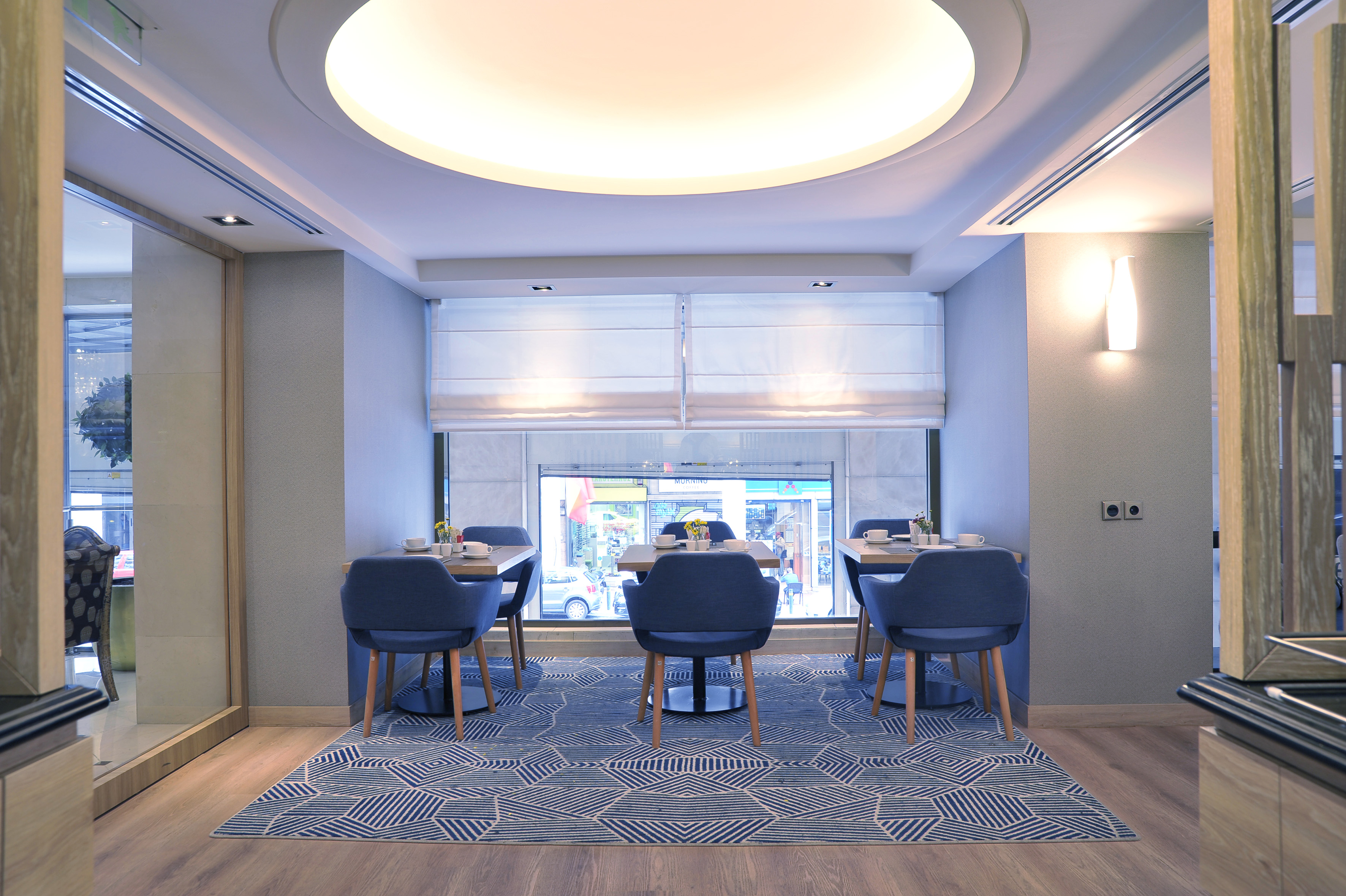 a room with blue chairs and a large window