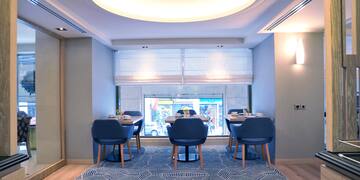 a room with blue chairs and a large window