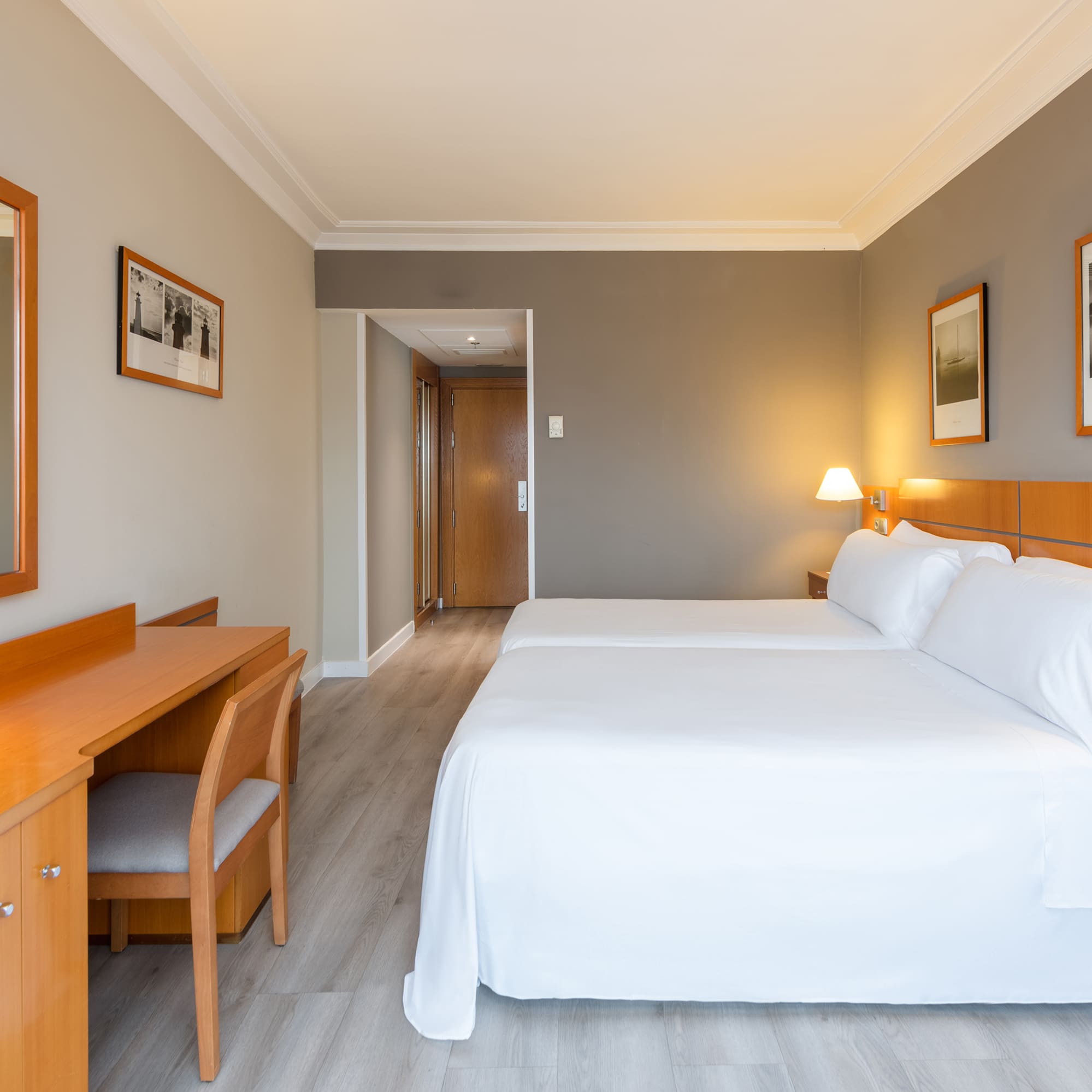 a room with two beds and a desk