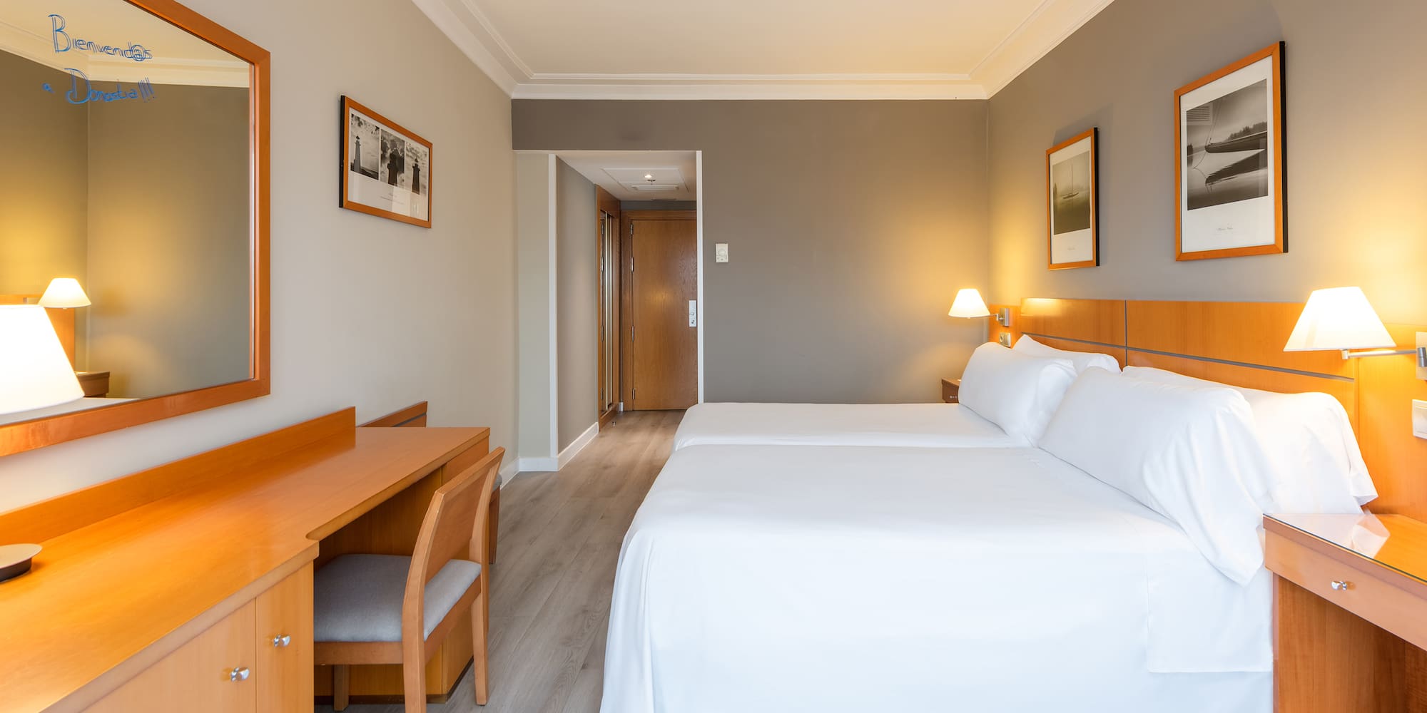 a room with two beds and a desk