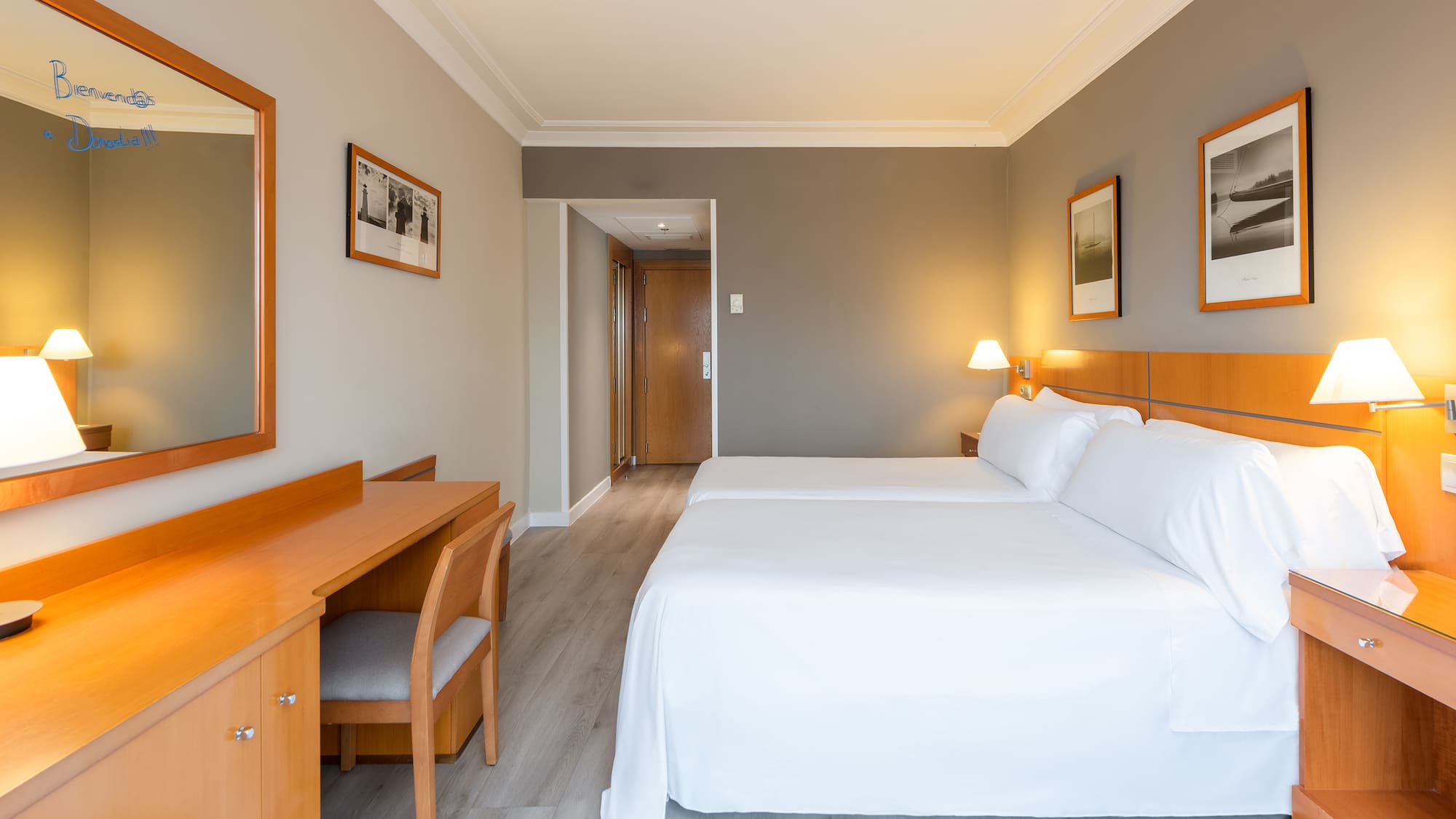 a room with two beds and a desk