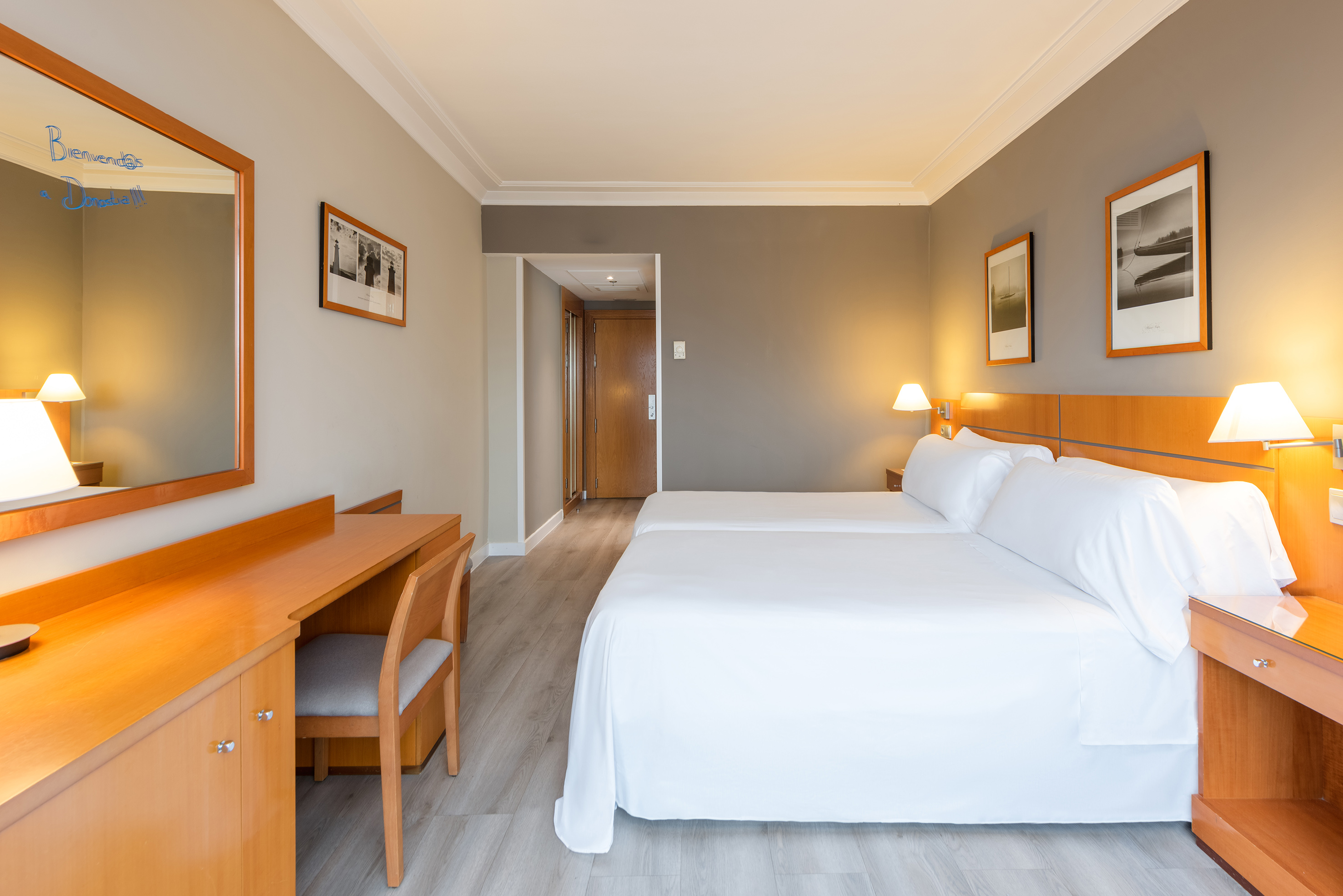 a room with two beds and a desk
