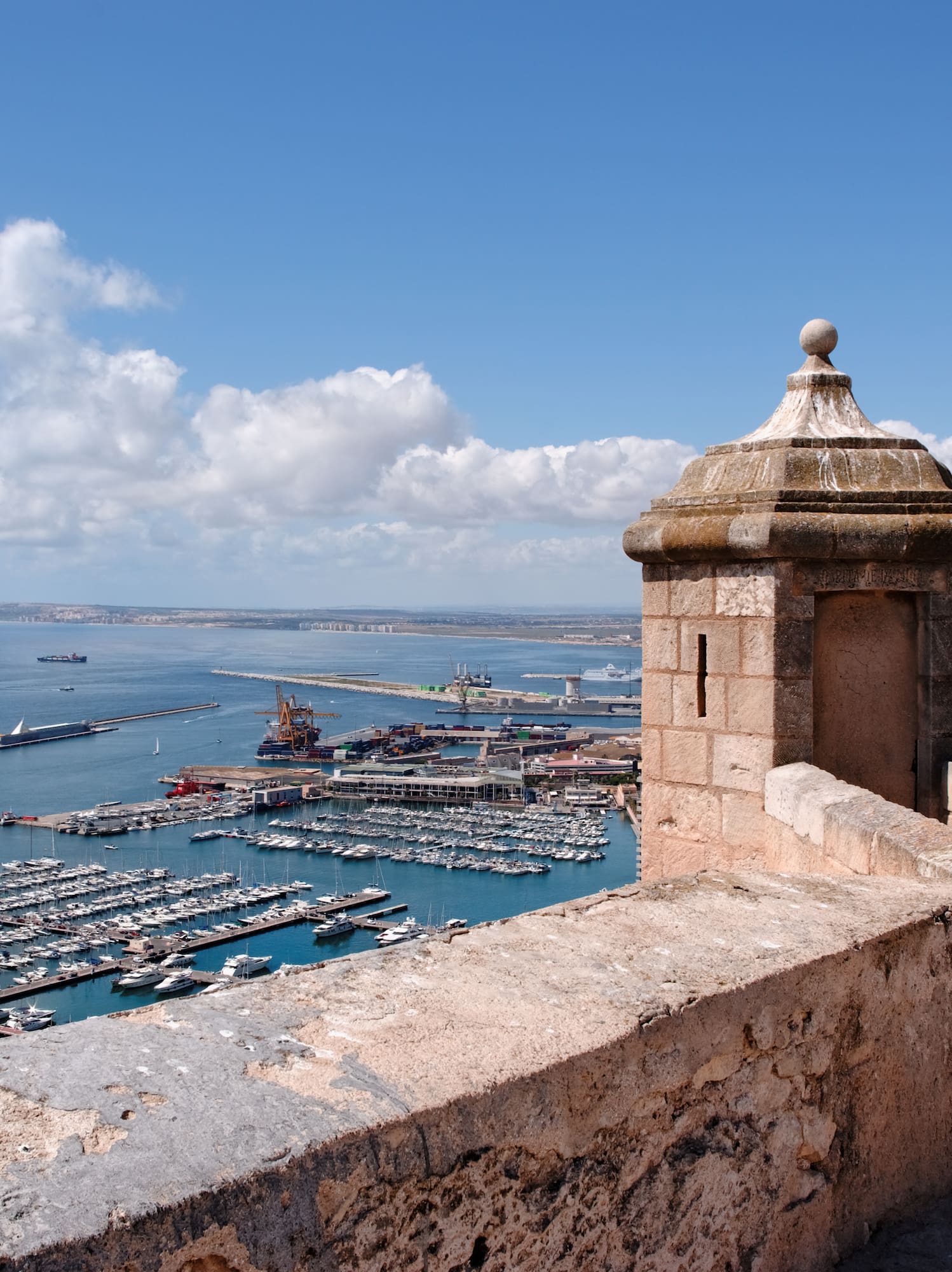 a stone wall with a city and a body of water