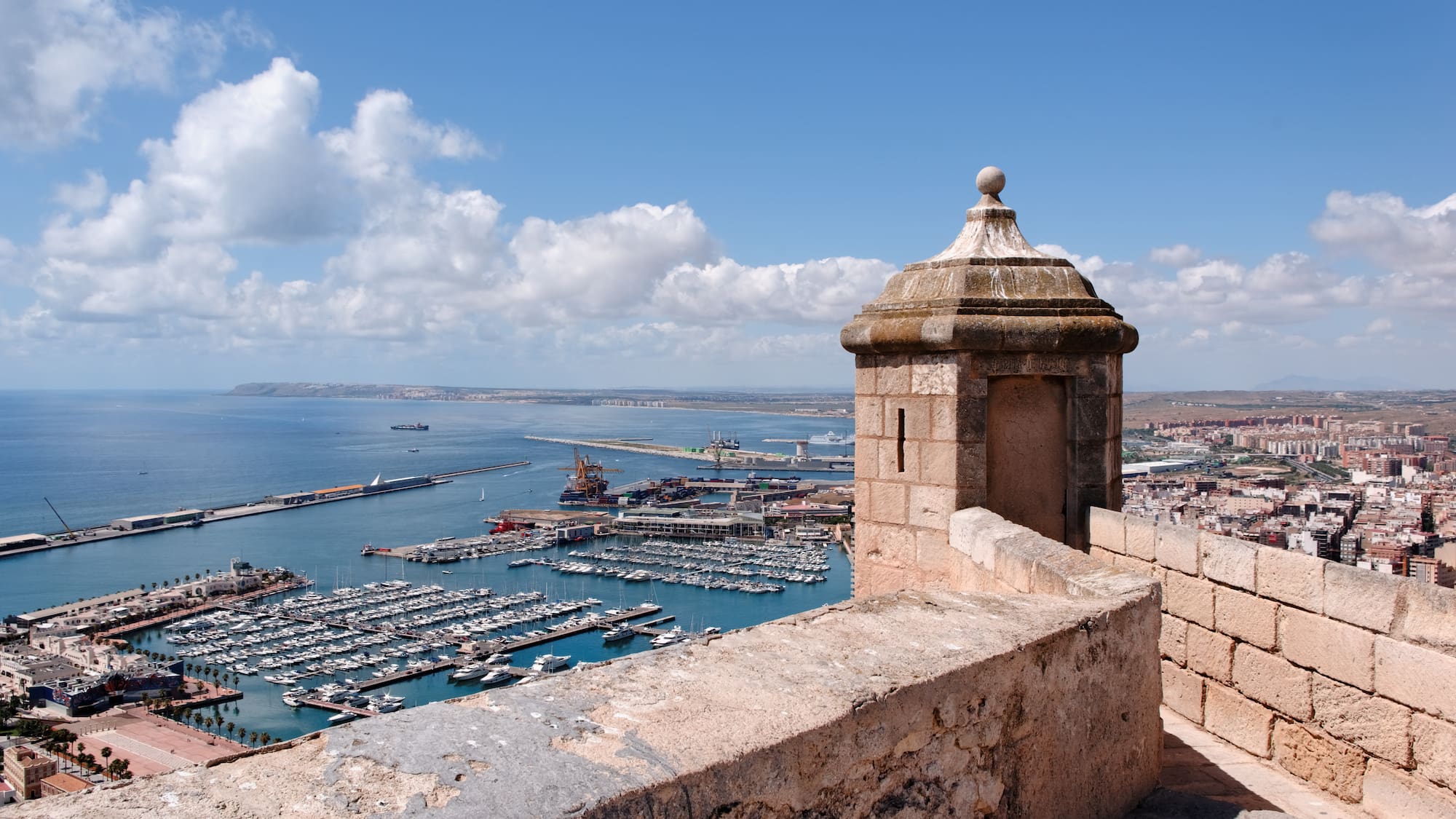 a stone wall with a city and a body of water
