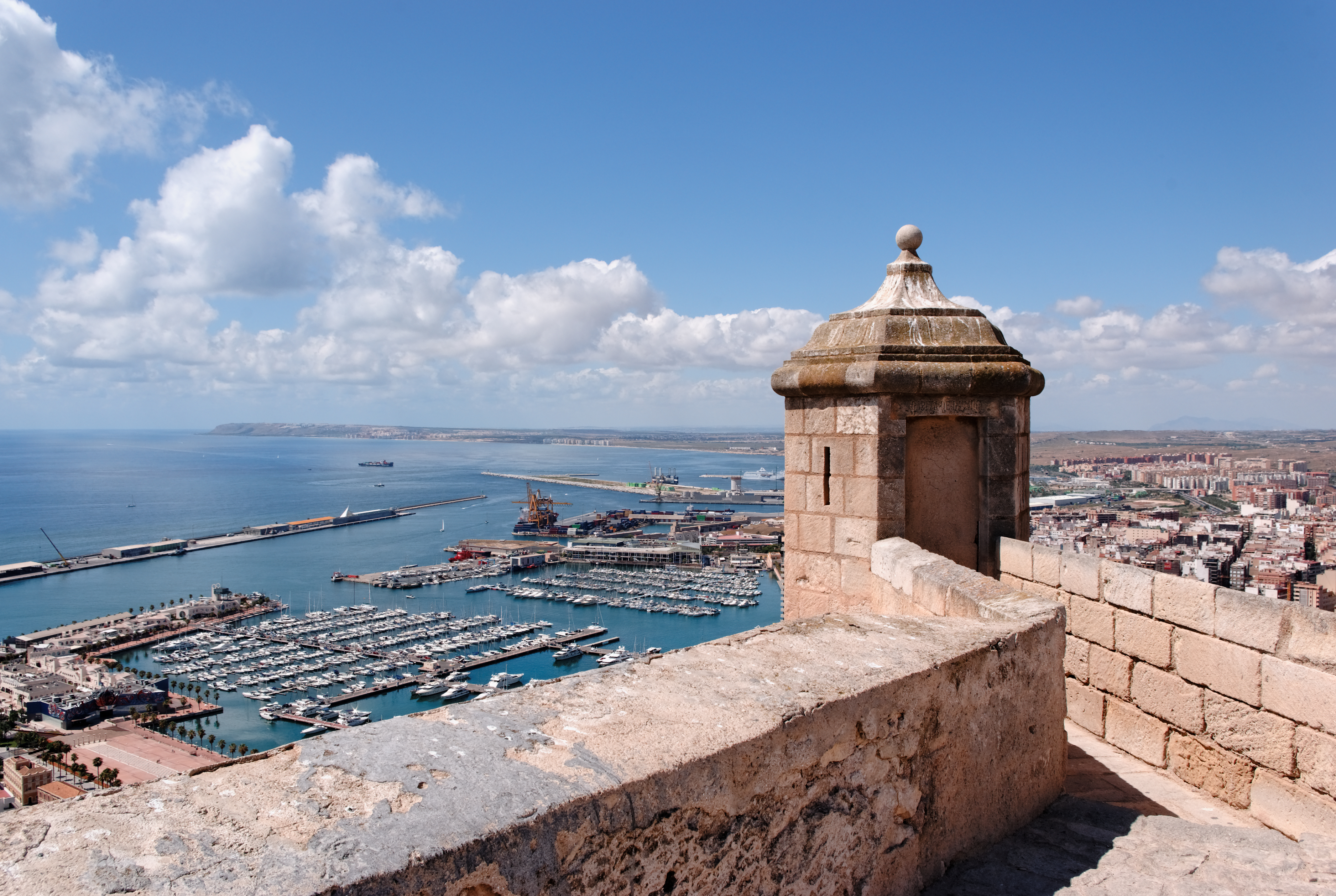 Alicante castle view of marina with yachts and coastal city.
