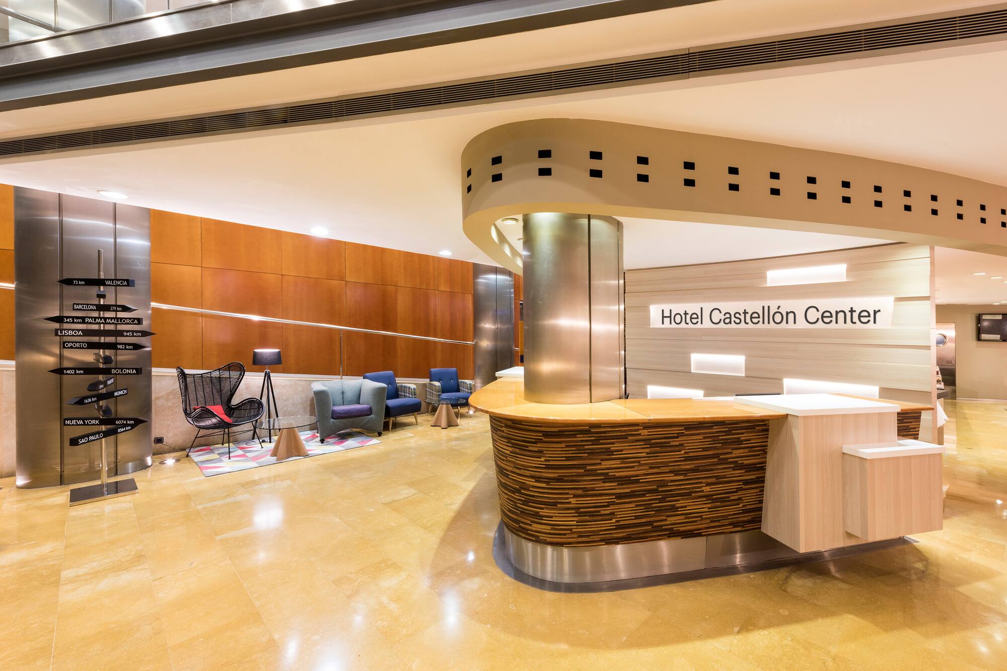 Hotel Castellón Center lobby, modern reception desk, destination signpost.